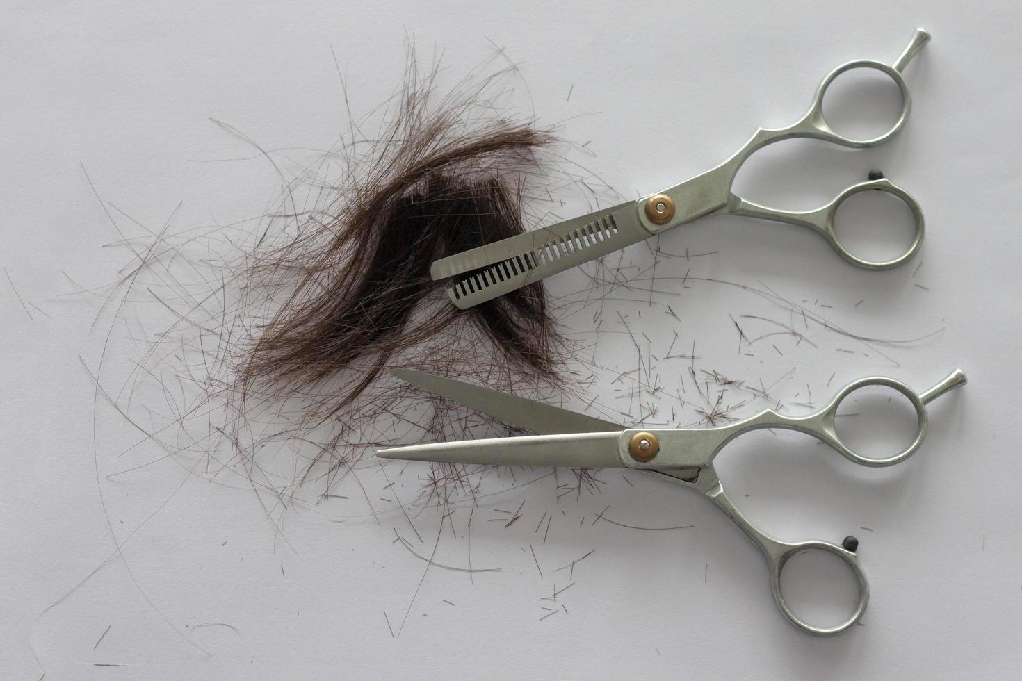 capelli e forbici per tagli di capelli su bianca carta sfondo. foto