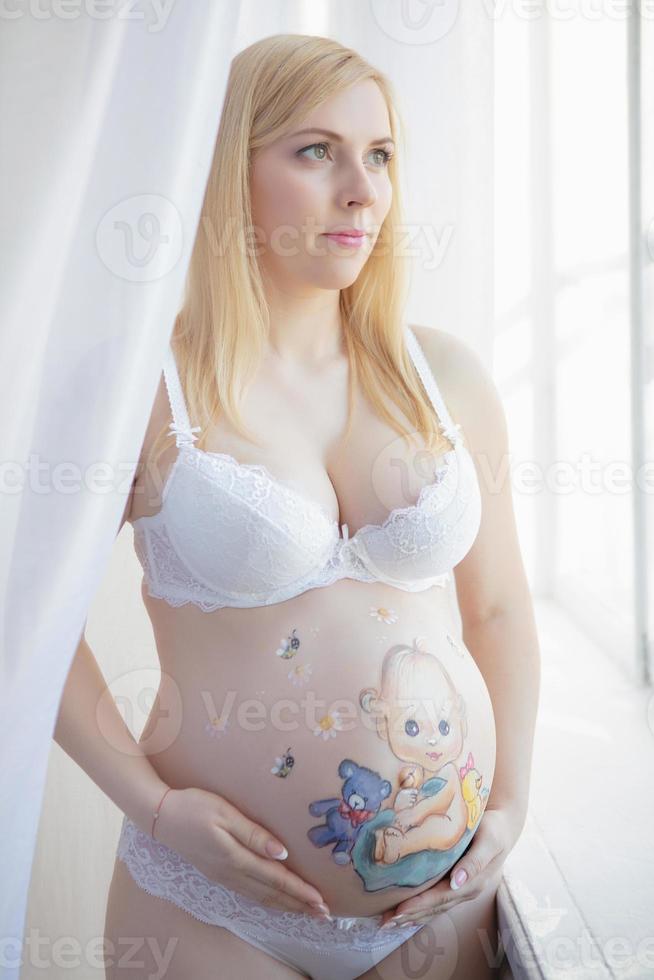 simpatico incinta donna con un' affascinante disegno su sua stomaco foto