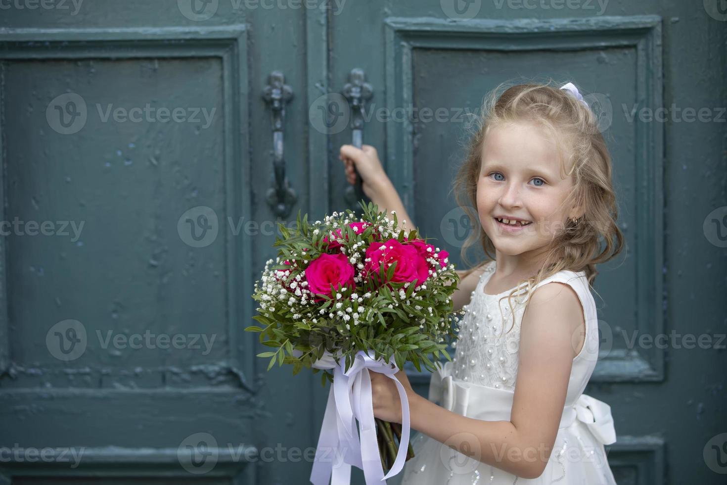 un' carino poco ragazza è Tenere un' mazzo di fiori. Da donna giorno. poco ragazza e fiore. contento bambino su vacanza con fiori. foto