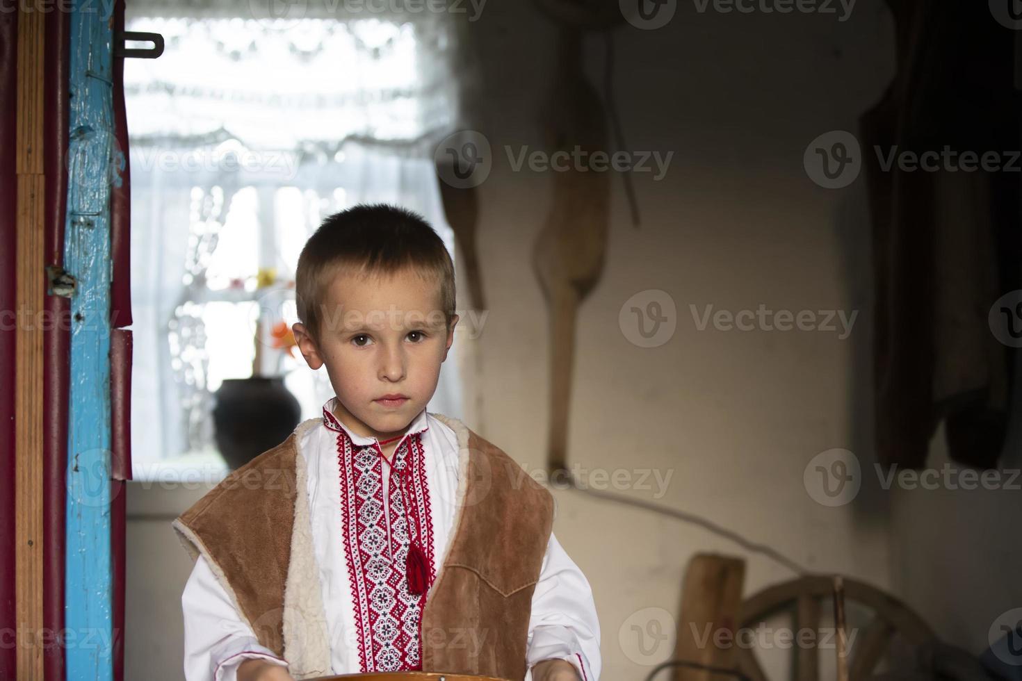 slavo poco ragazzo bielorusso o ucraino nel nazionale Abiti su un' rustico sfondo. foto