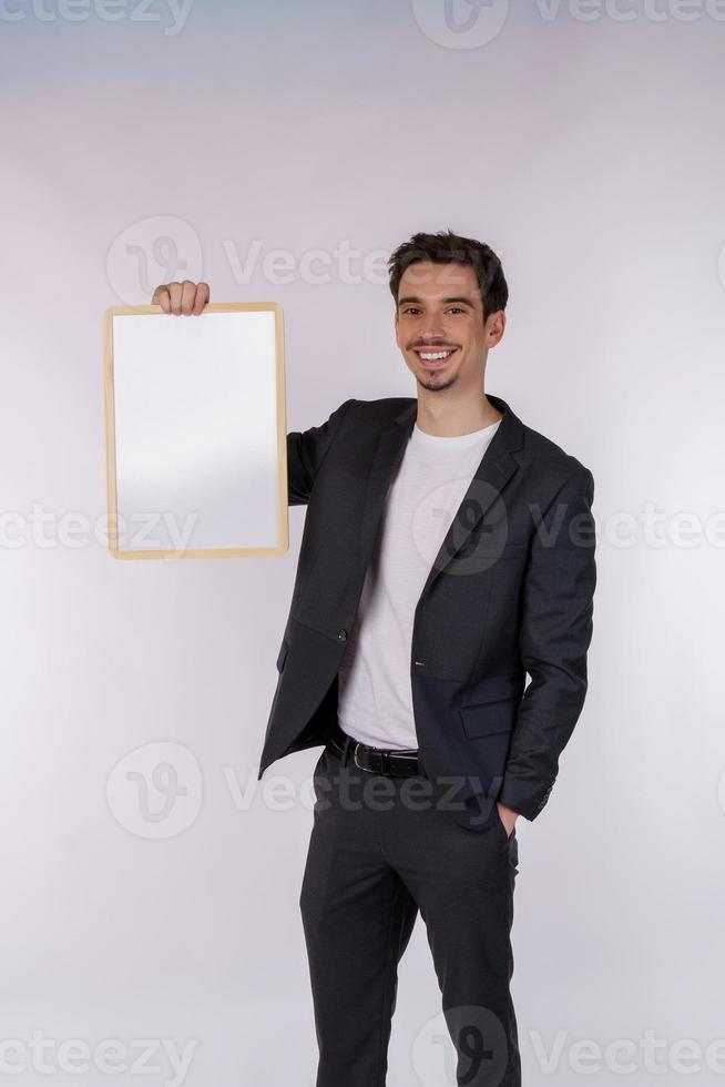 ritratto di contento uomo d'affari mostrando vuoto cartello su isolato bianca sfondo foto