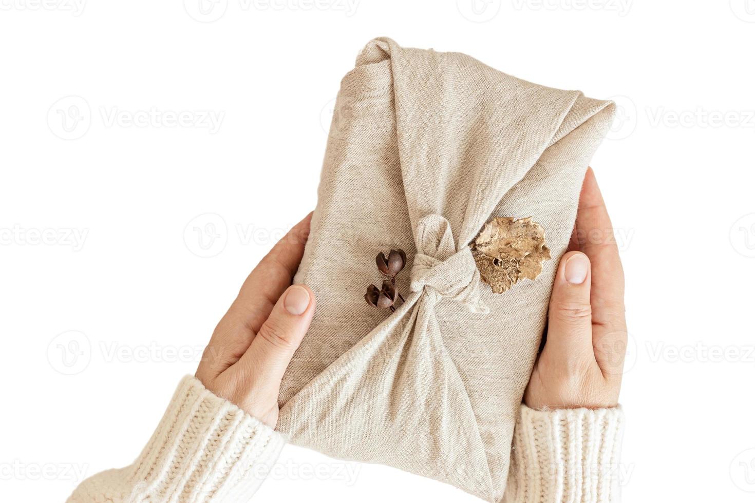 6440 beige stoffa avvolto un' regalo tenuto di un' donna di mani isolato su un' trasparente sfondo foto