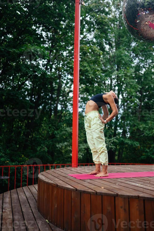 un' giovane donna nel fare yoga nel il cortile foto
