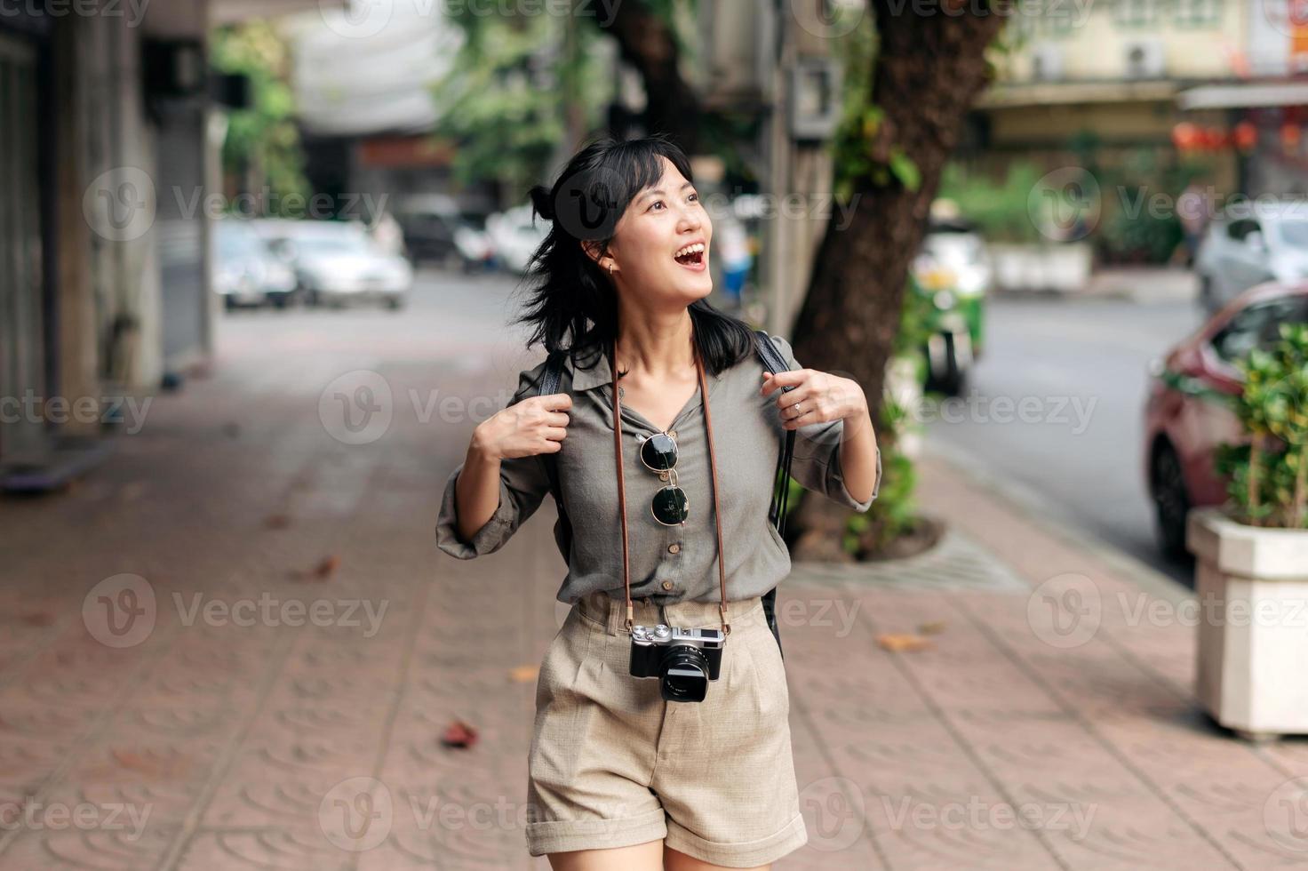 giovane asiatico donna zaino viaggiatore godendo strada culturale Locale posto e Sorridi. viaggiatore controllo su lato strade. foto