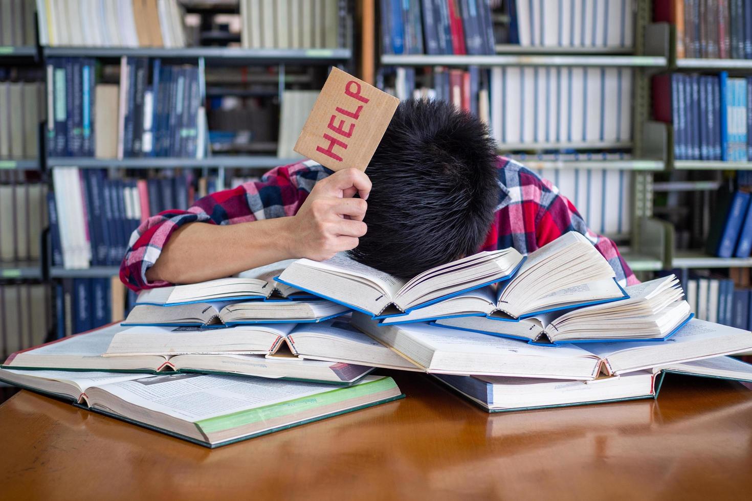 asiatico maschio studenti siamo stanco e stressato con lettura un' lotto per preparare per il esame. foto