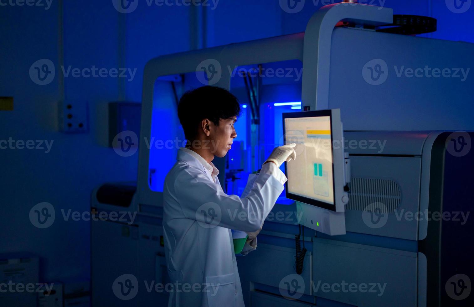 giovane scienziato Lavorando con automazione sangue analizzatore rapporto nel medico laboratorio foto