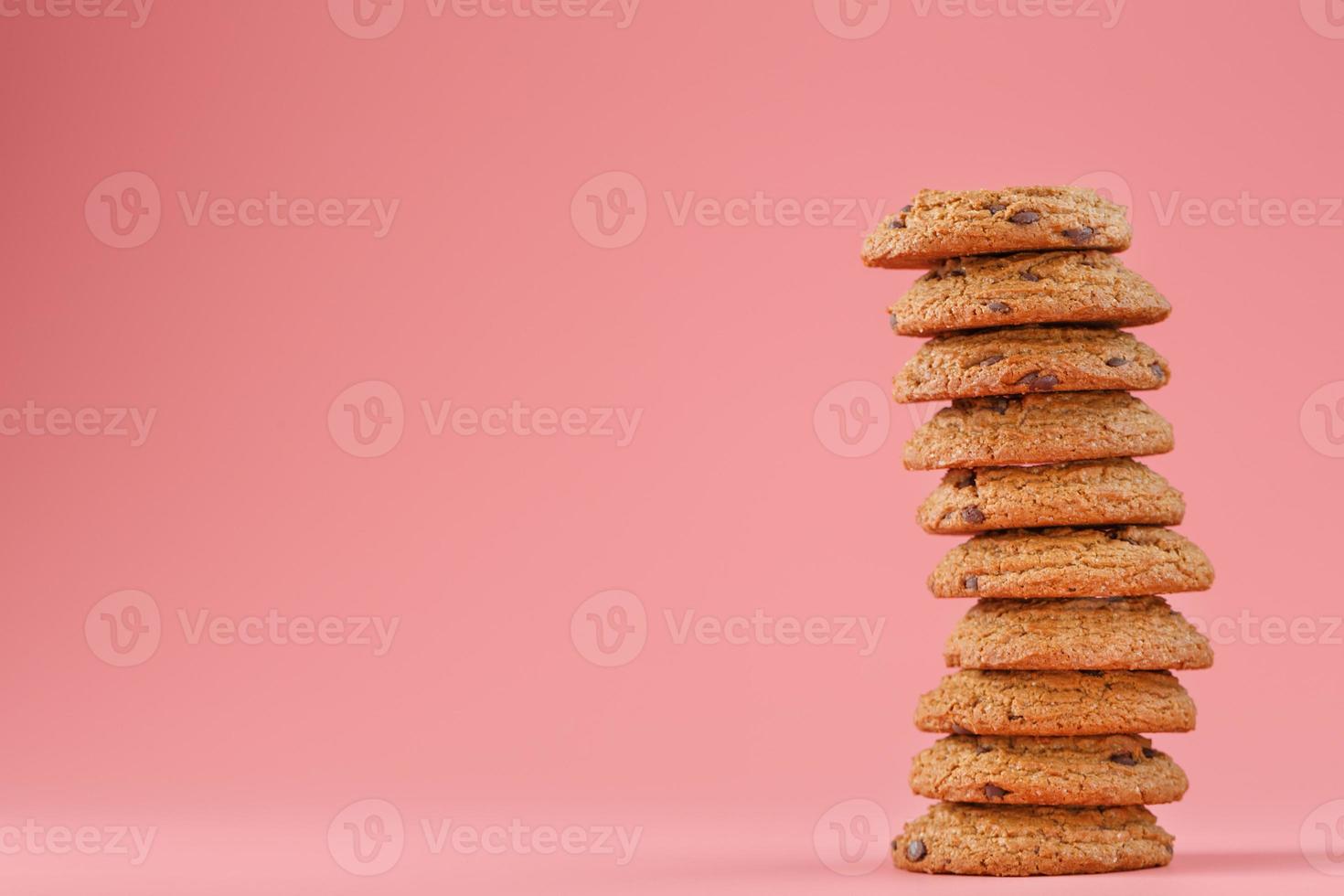 fiocchi d'avena biscotti con cioccolato siamo impilati su un' rosa sfondo. foto