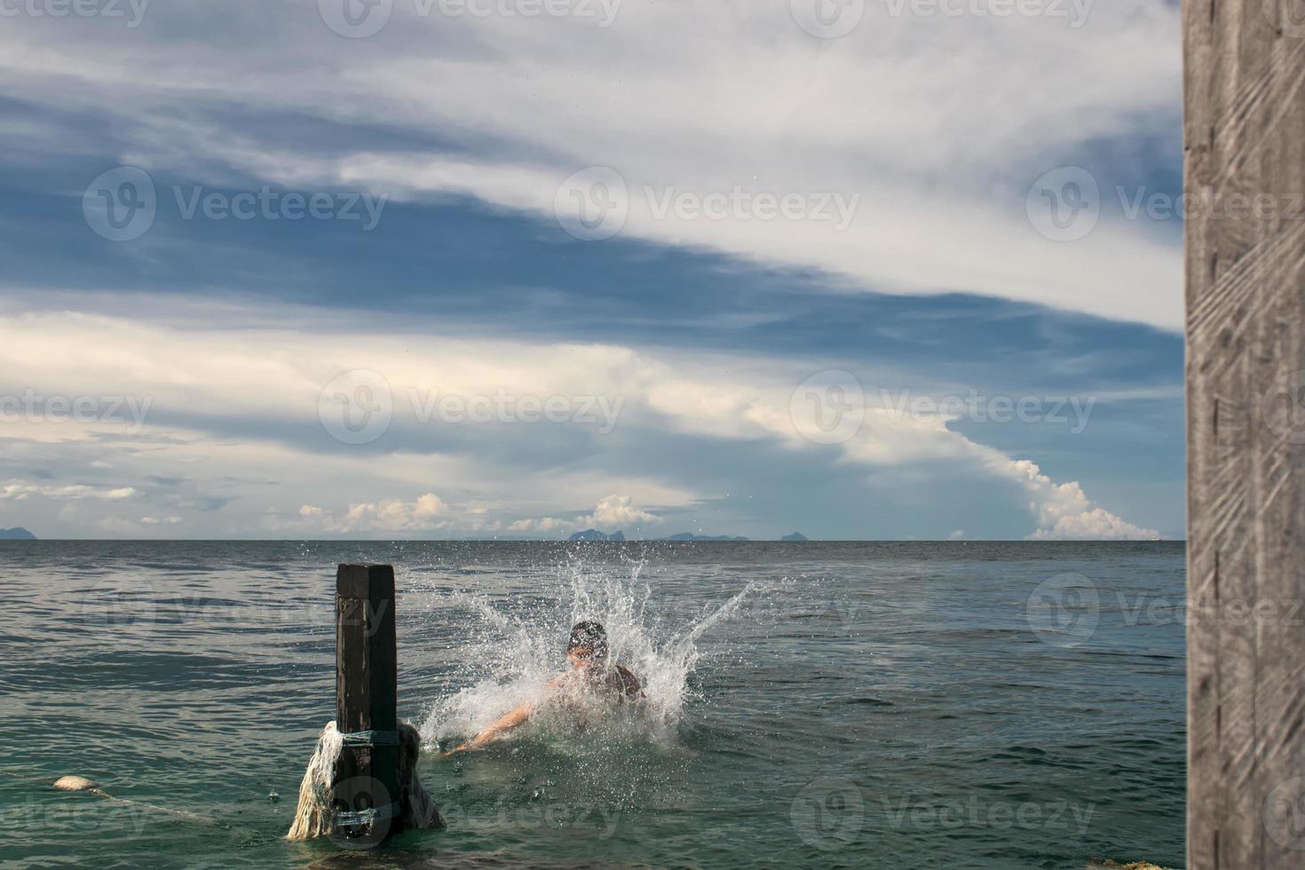 un' giovane ragazzo immersione in il cristallo acqua di kapalai Malaysia foto