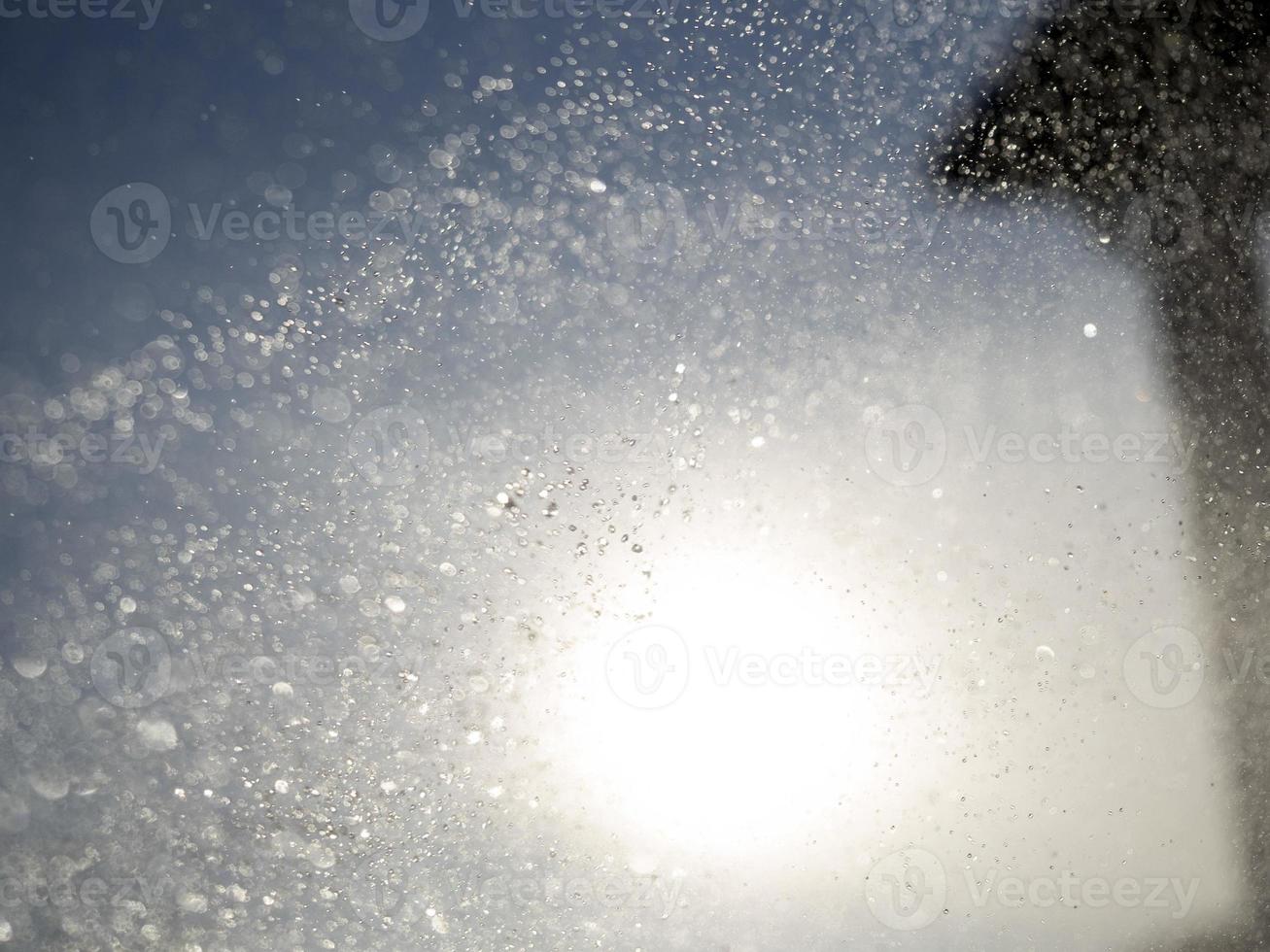 acqua gocce spray dettaglio su sole sfondo foto