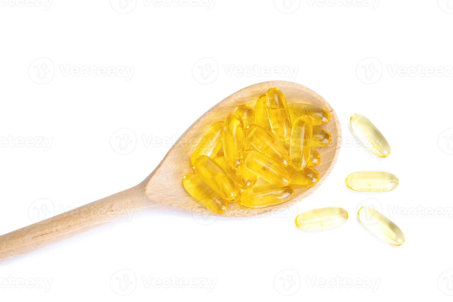 mucchio di capsule molli capsule omega 3 nel di legno cucchiaio isolato su bianca sfondo. foto