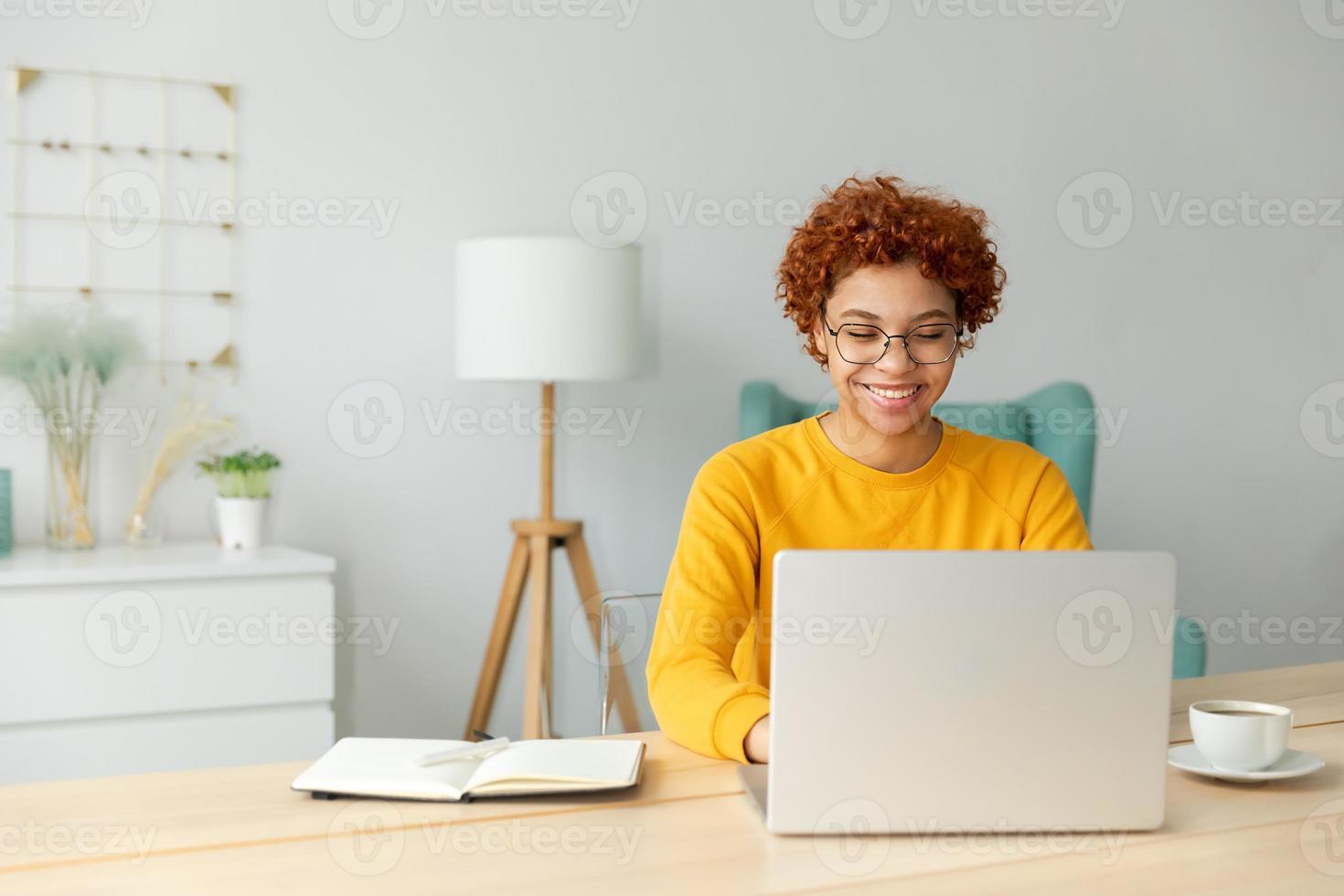 africano americano ragazza utilizzando il computer portatile a casa ufficio guardare a schermo digitando chat lettura scrittura e-mail. giovane donna avendo virtuale incontro in linea Chiacchierare video chiamata conferenza opera apprendimento a partire dal casa foto