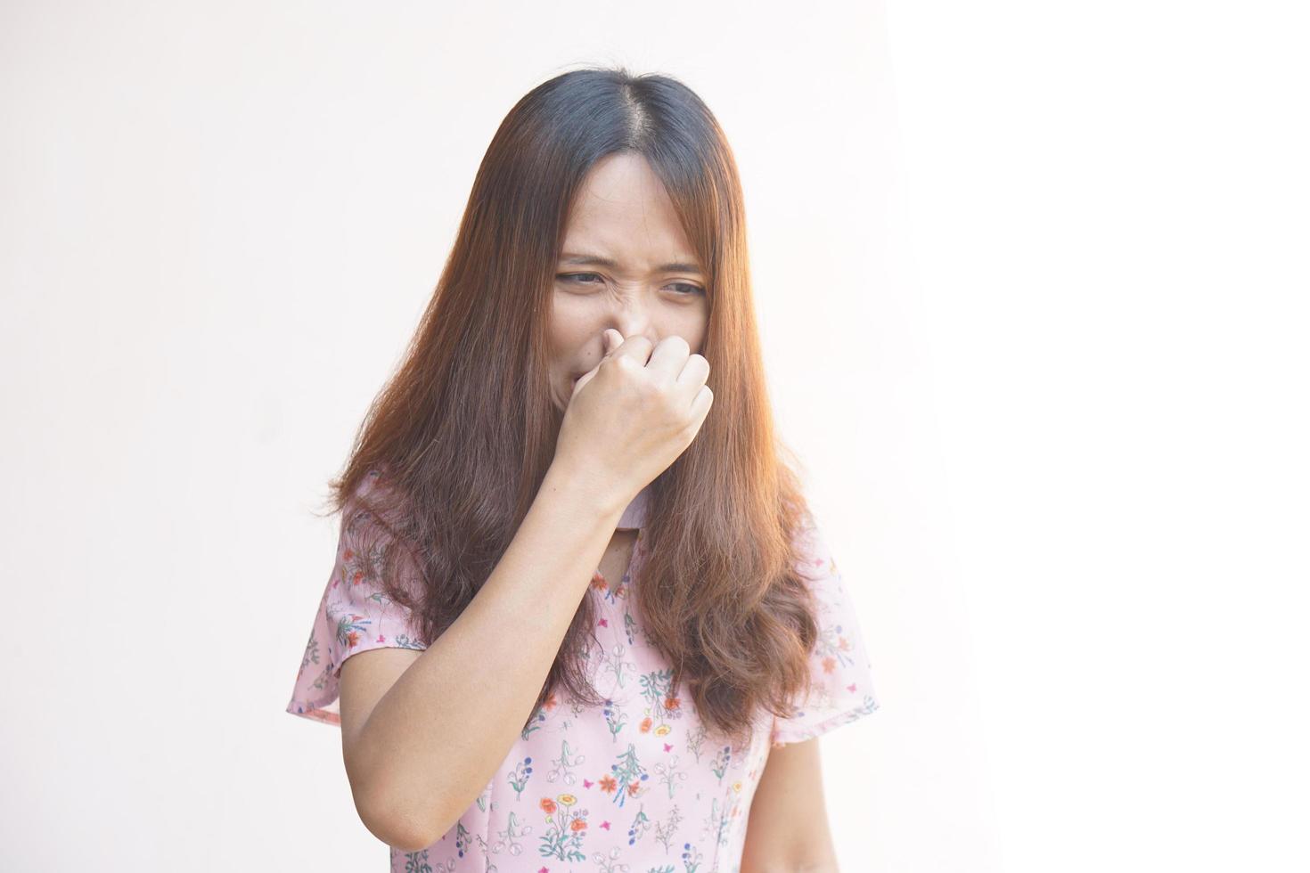 asiatico donna copertura sua naso con sua dito a partire dal il fetore foto