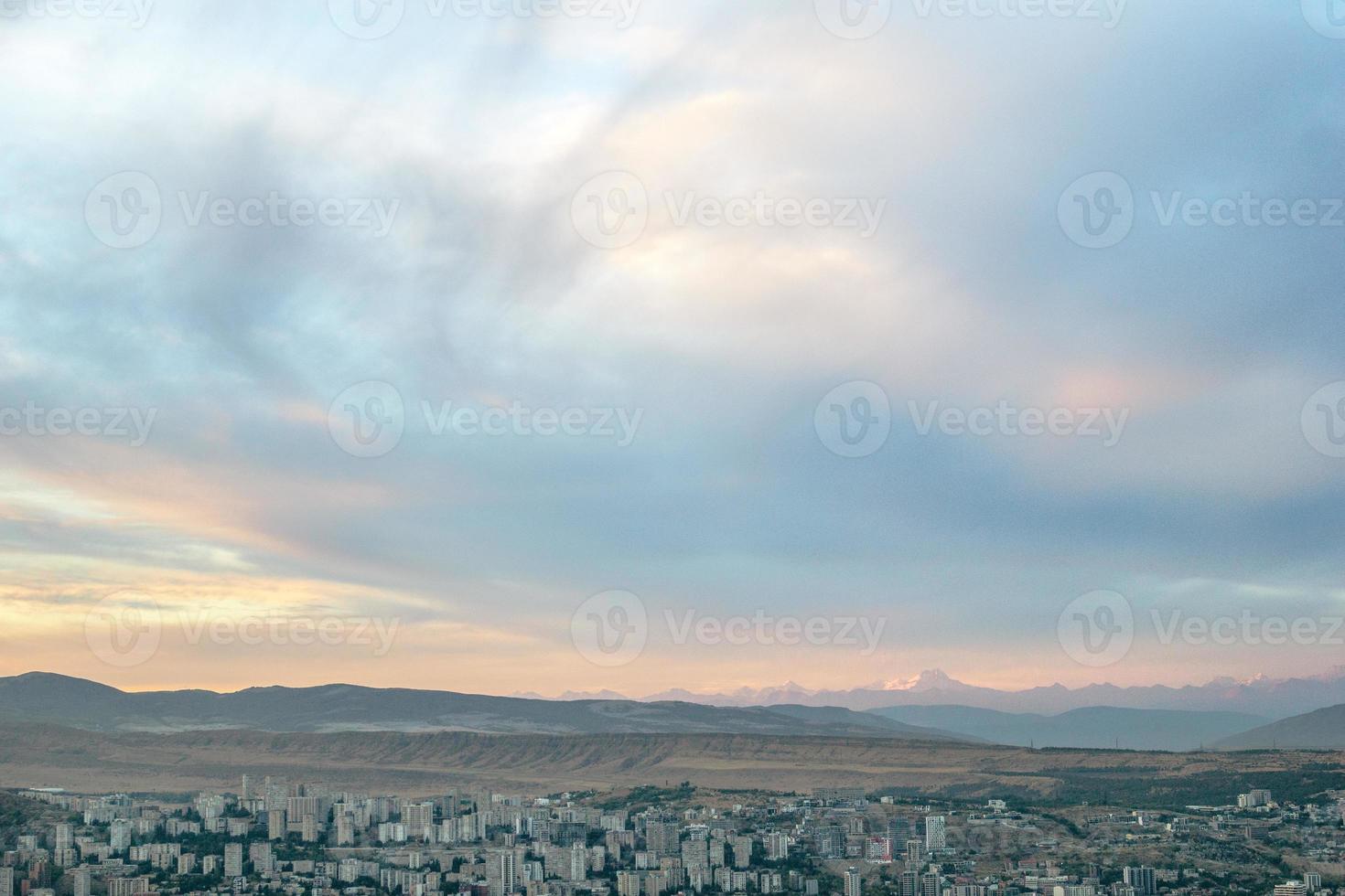 panoramico Visualizza su Tbilisi città paesaggio urbano a crepuscolo con bellissimo tramonto al di sopra di il colline. foto