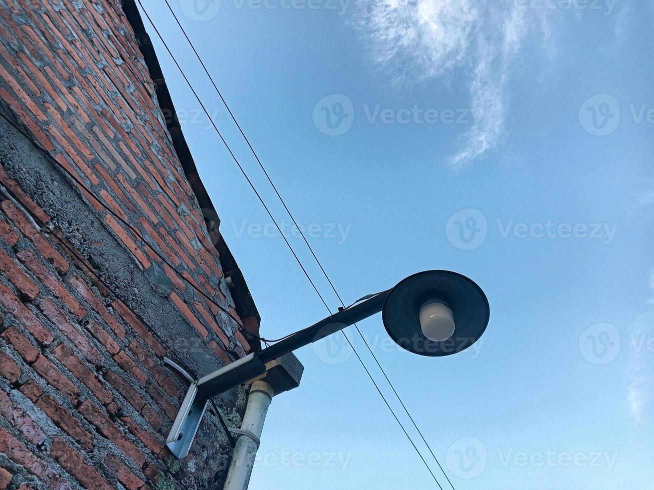 strada lampada Il prossimo per mattone parete con blu cielo foto