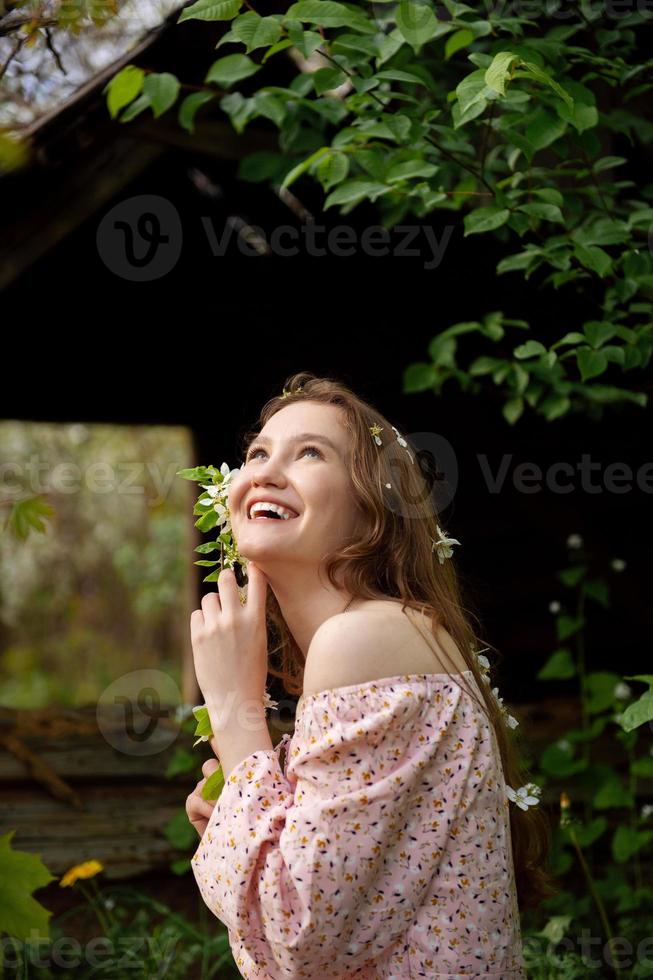 il ragazza è in piedi sotto un' albero con sua occhi Chiuso. bianca petali siamo caduta su il viso foto