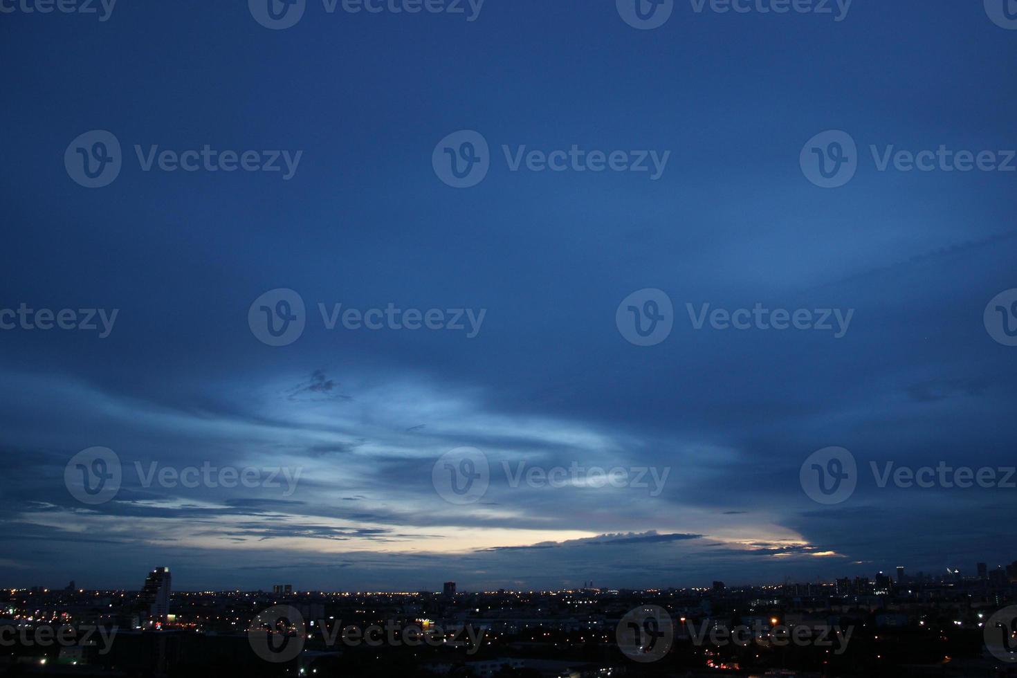 buio blu nube con bianca leggero cielo sfondo e città leggero mezzanotte sera tempo foto