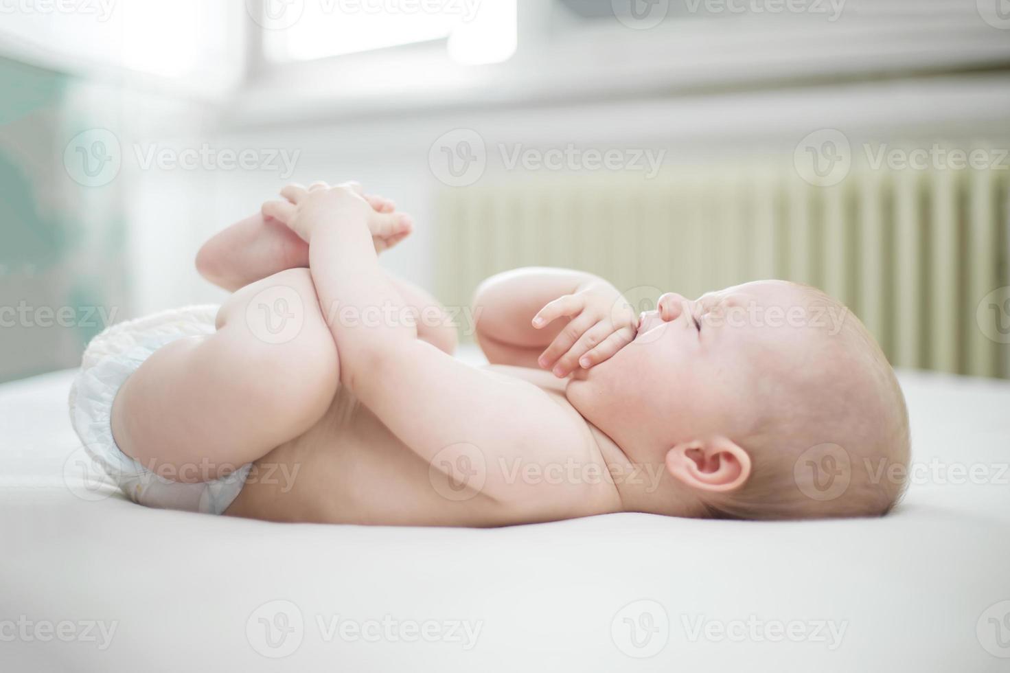 bambina carina che piange sul letto foto