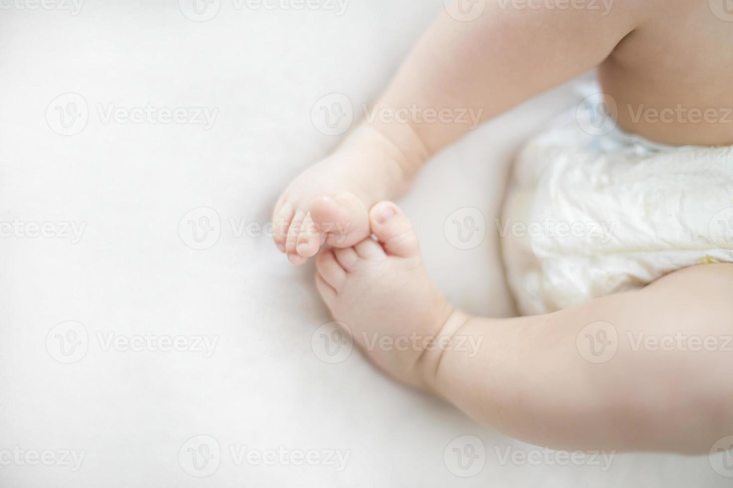 piccoli piedi della neonata sul letto foto