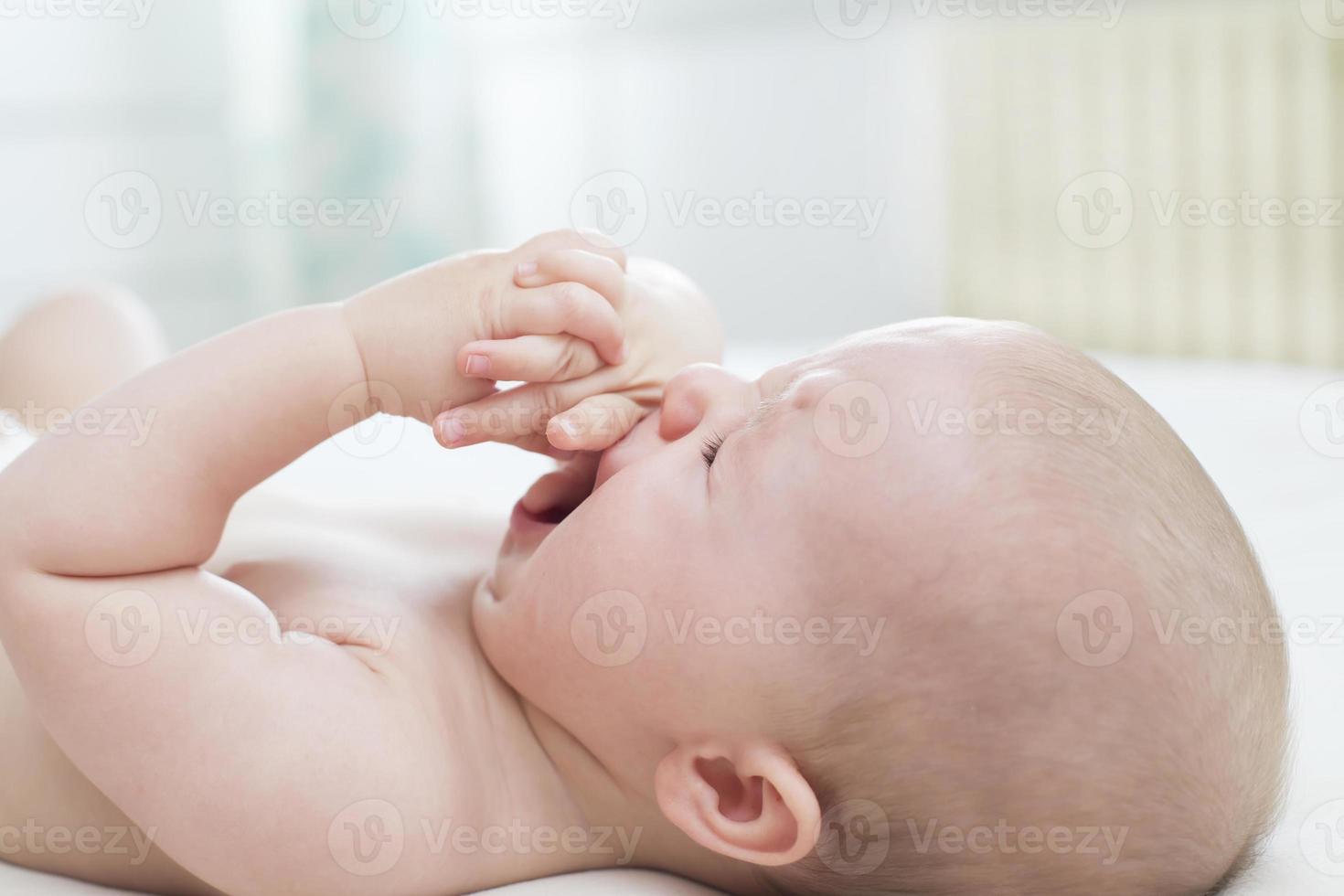 bambina carina che piange sul letto foto