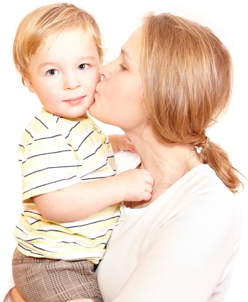 madre che bacia figlio su uno sfondo bianco foto