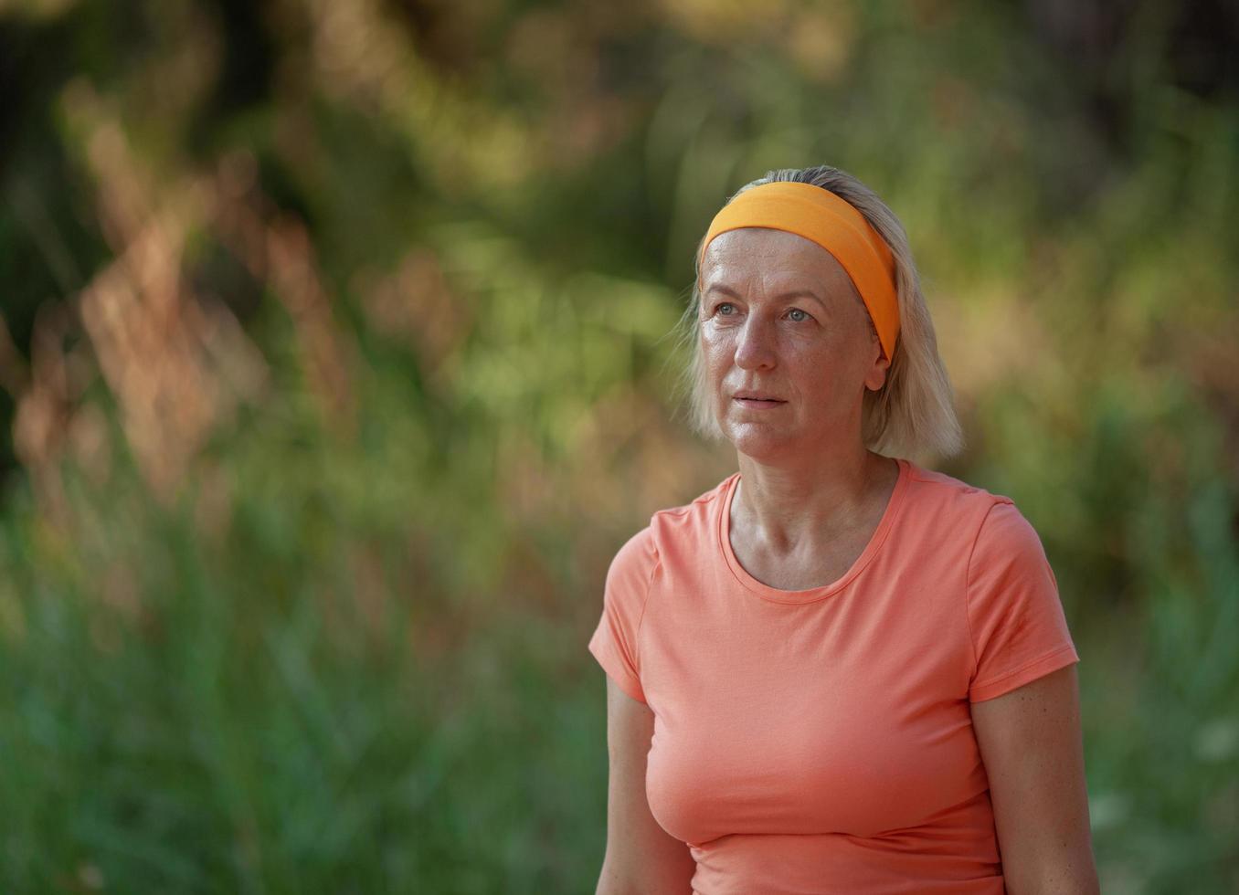 donna matura che esercitano in un parco foto