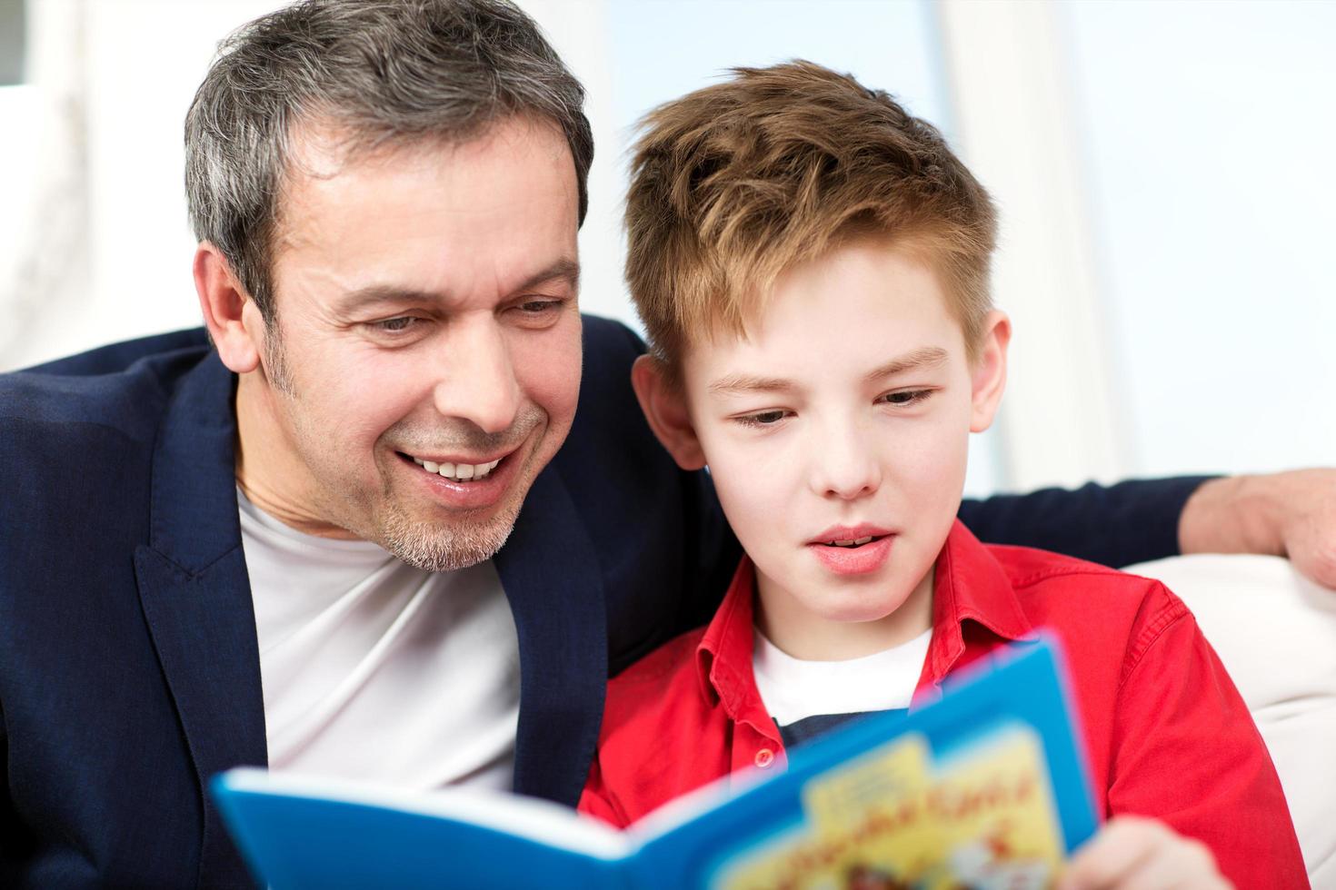 padre e figlio che leggono un libro foto