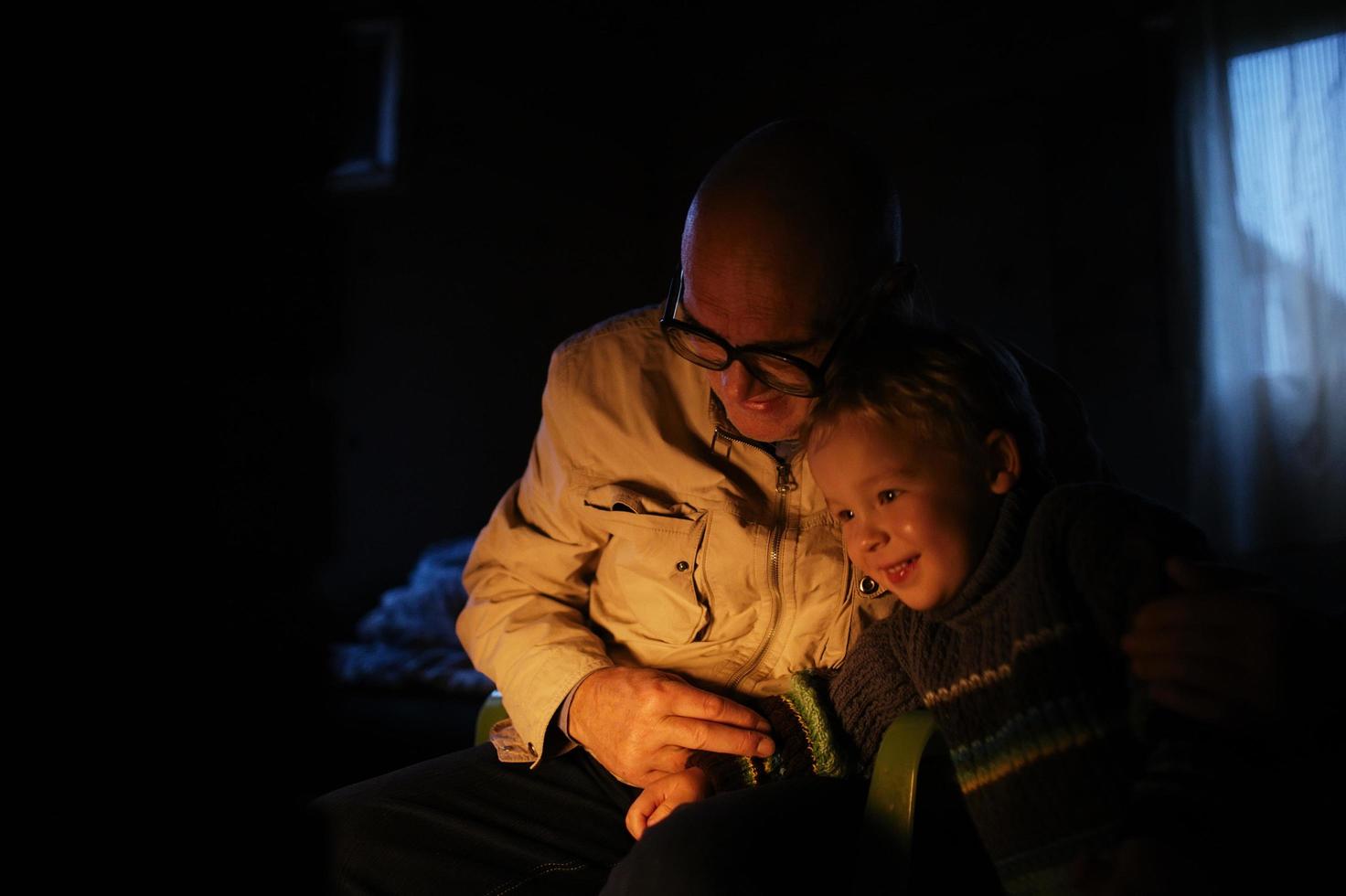 il nonno abbraccia suo nipote vicino al camino foto