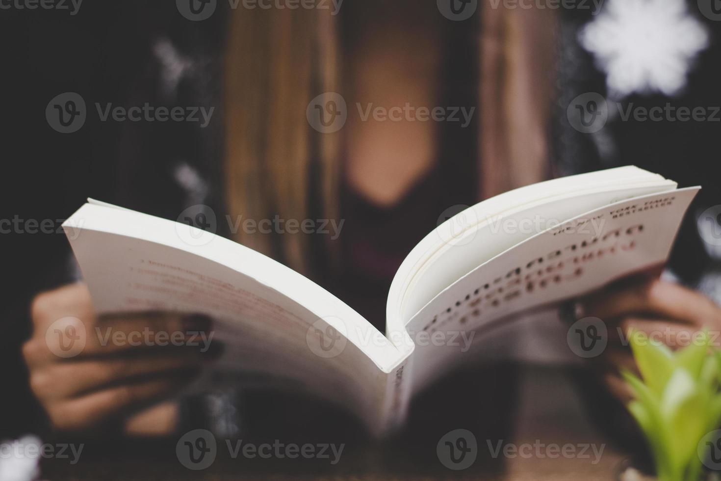 primo piano della donna che tiene un libro foto