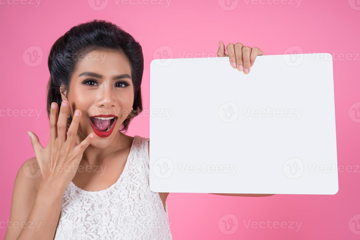 ritratto di una donna alla moda che mostra uno striscione bianco foto