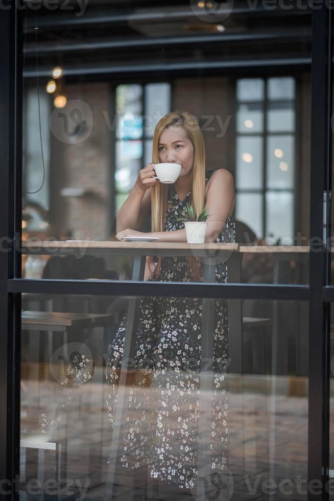 bella donna in un caffè che beve caffè foto