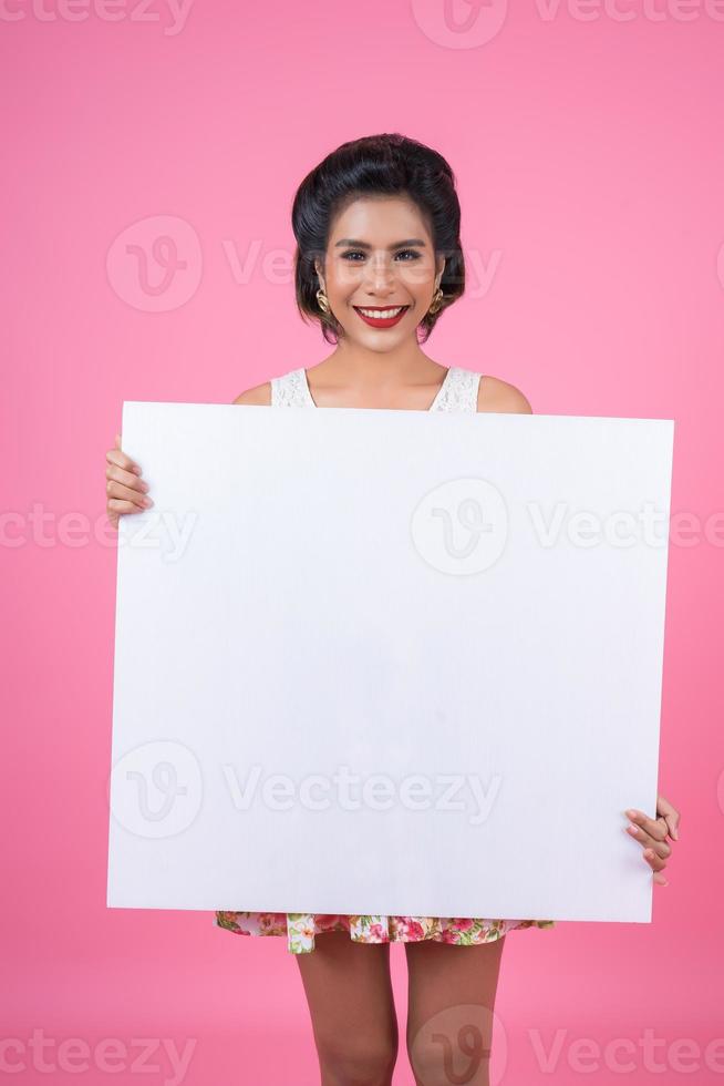 ritratto di una donna alla moda che mostra uno striscione bianco foto