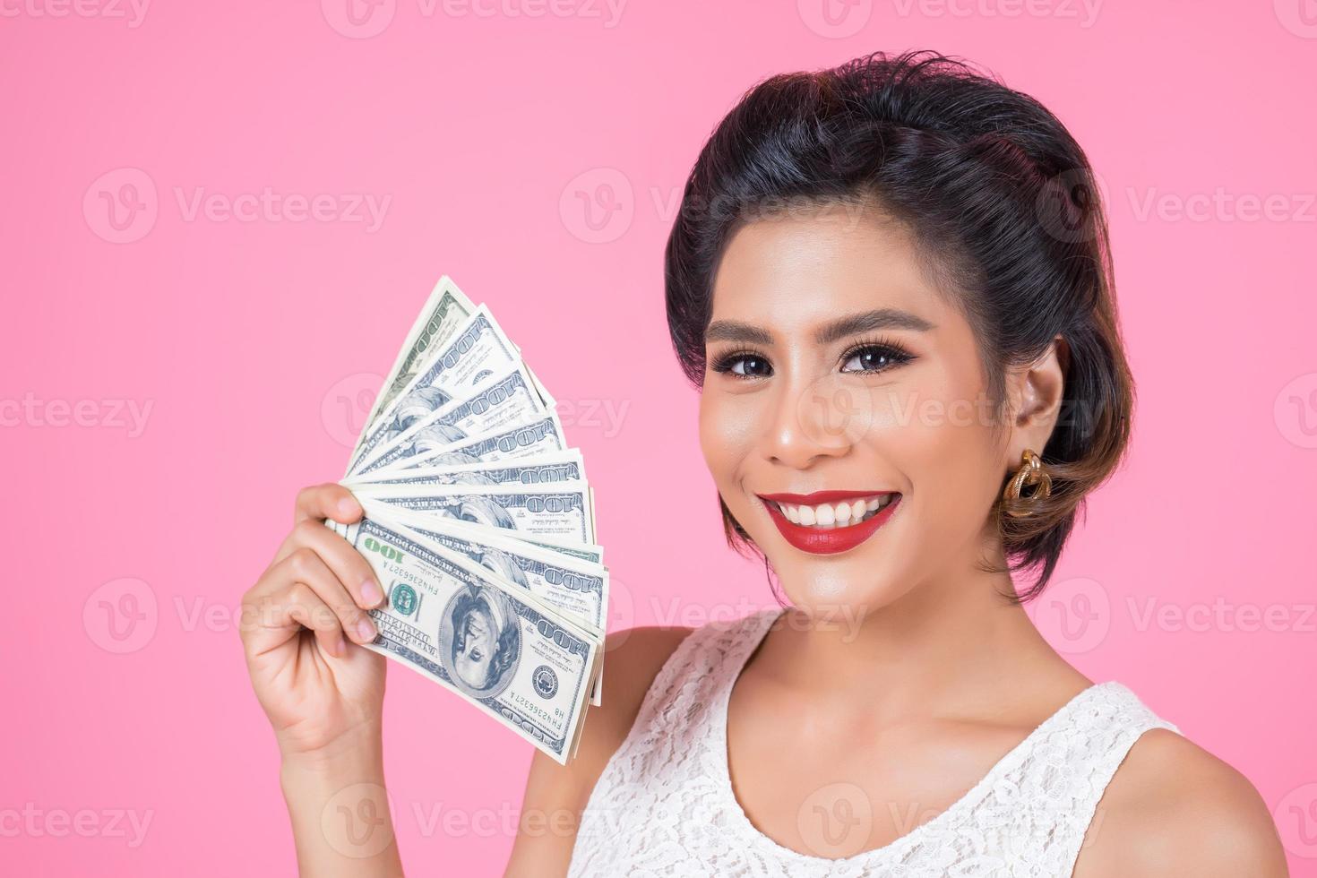 bella donna felice che tiene i dollari foto