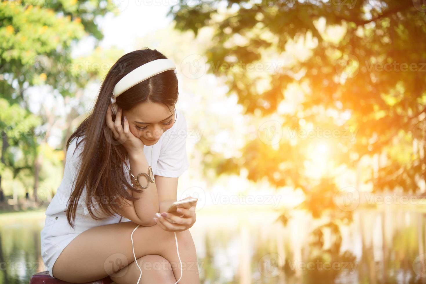 ritratto di una ragazza sorridente con le cuffie che ascolta la musica in natura foto