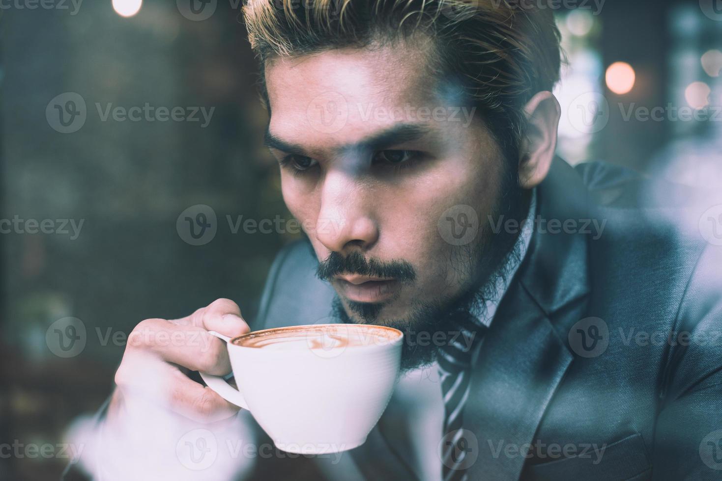 uomo d'affari che beve caffè nella caffetteria della città durante l'ora di pranzo foto