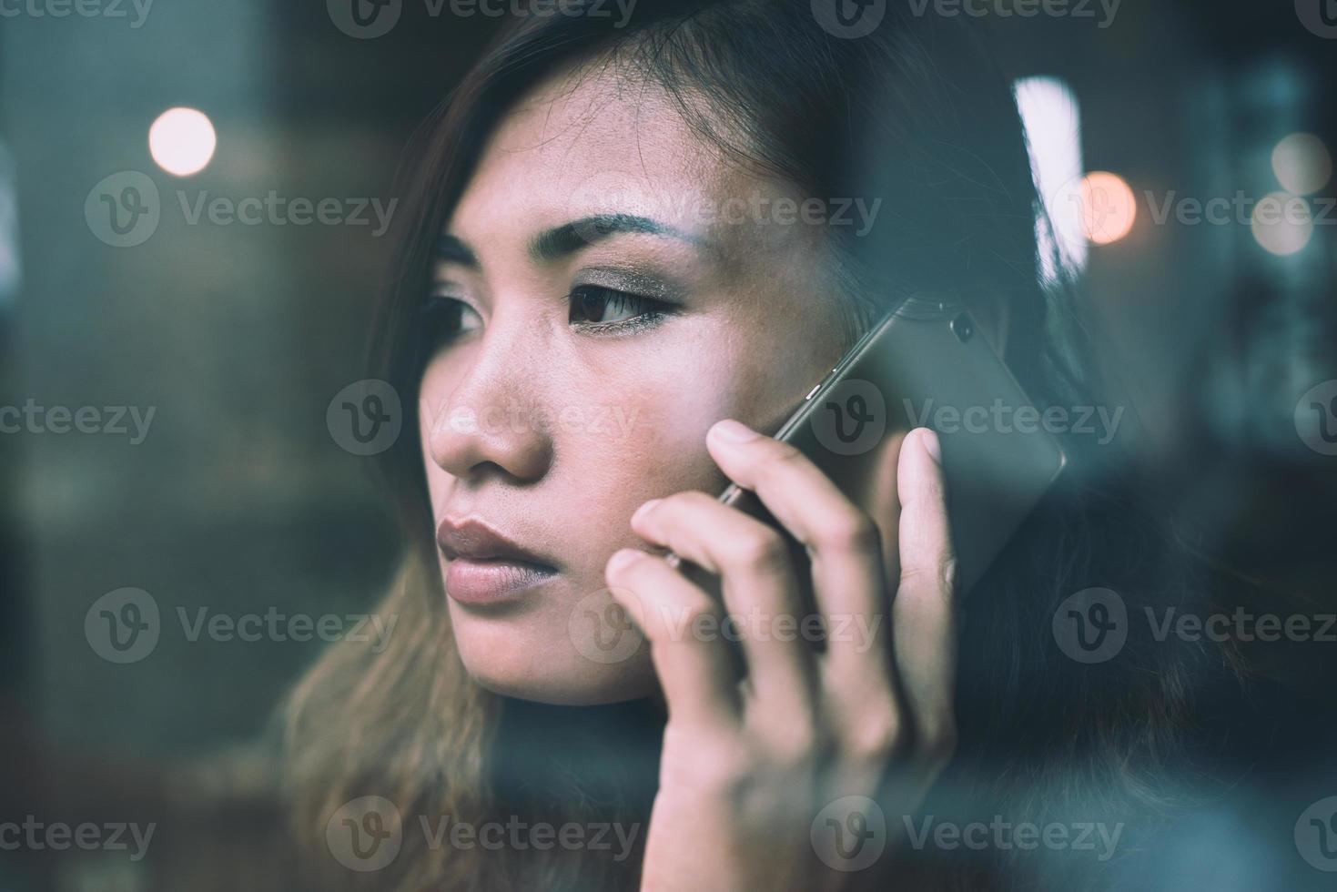 giovane donna che parla al telefono cellulare durante il resto nella caffetteria foto