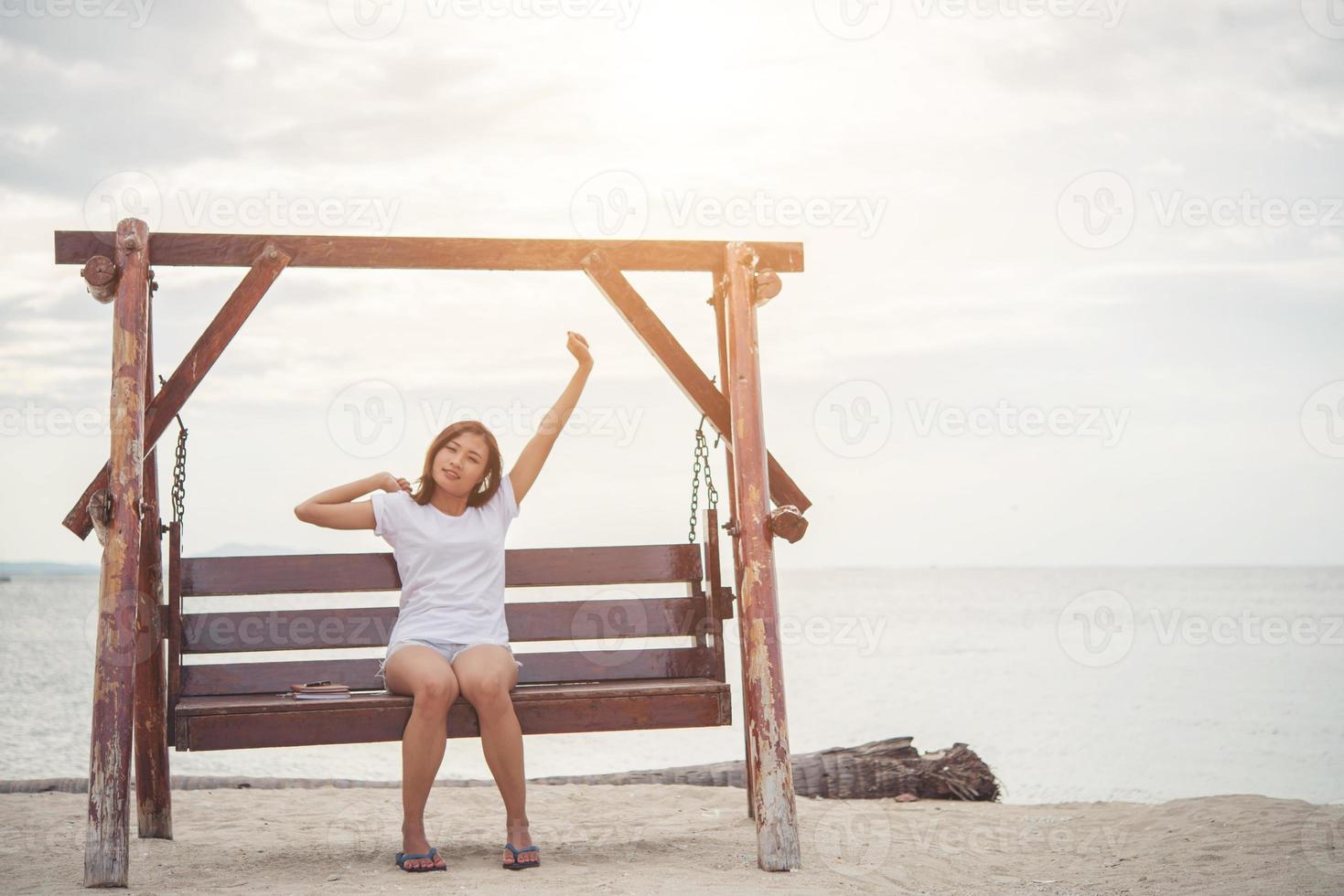 bella donna che si estende su un'altalena sulla spiaggia foto