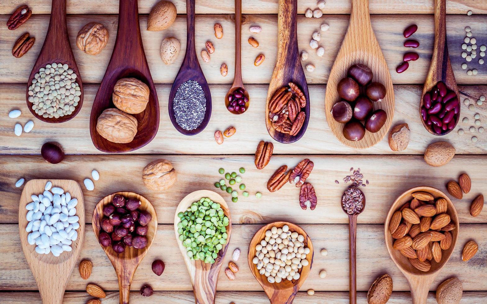 legumi e noci su cucchiai di legno foto