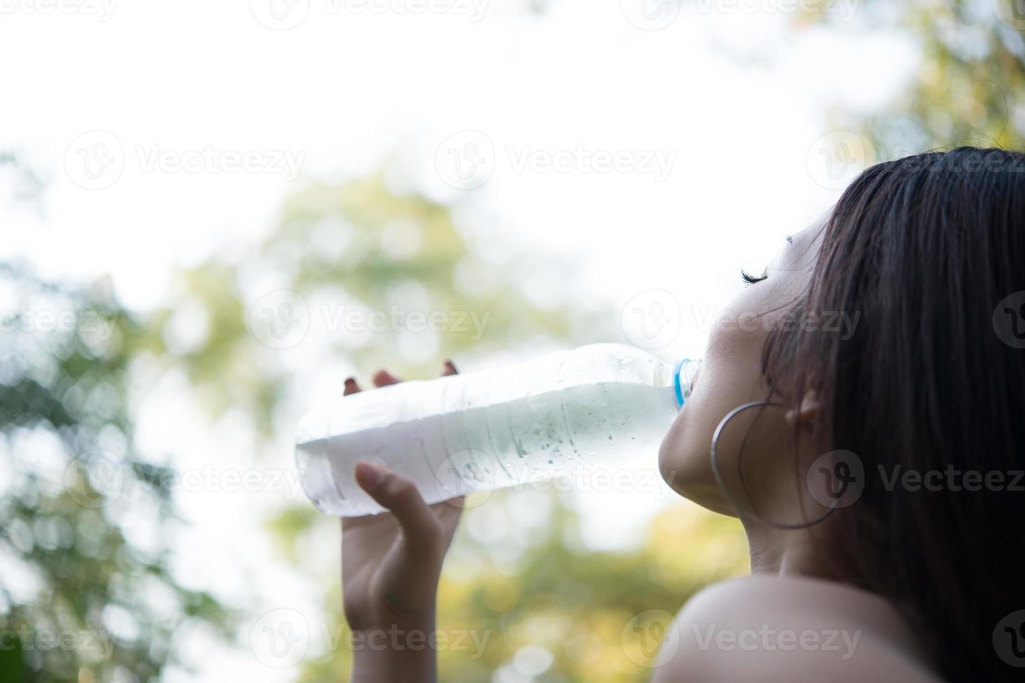 giovane bella donna che si rilassa all'aperto acqua potabile nel parco foto