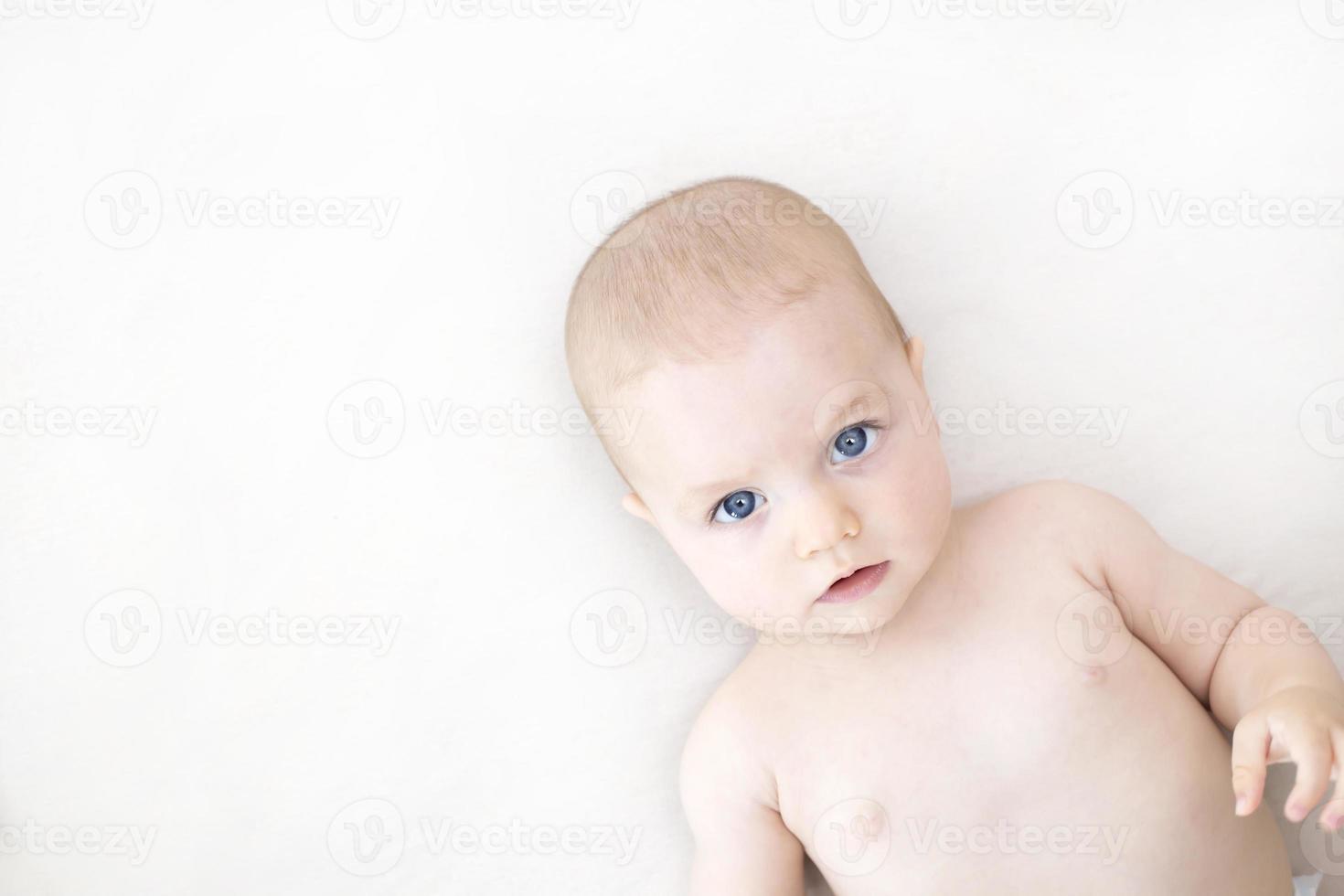 bambina carina sdraiata sul letto foto