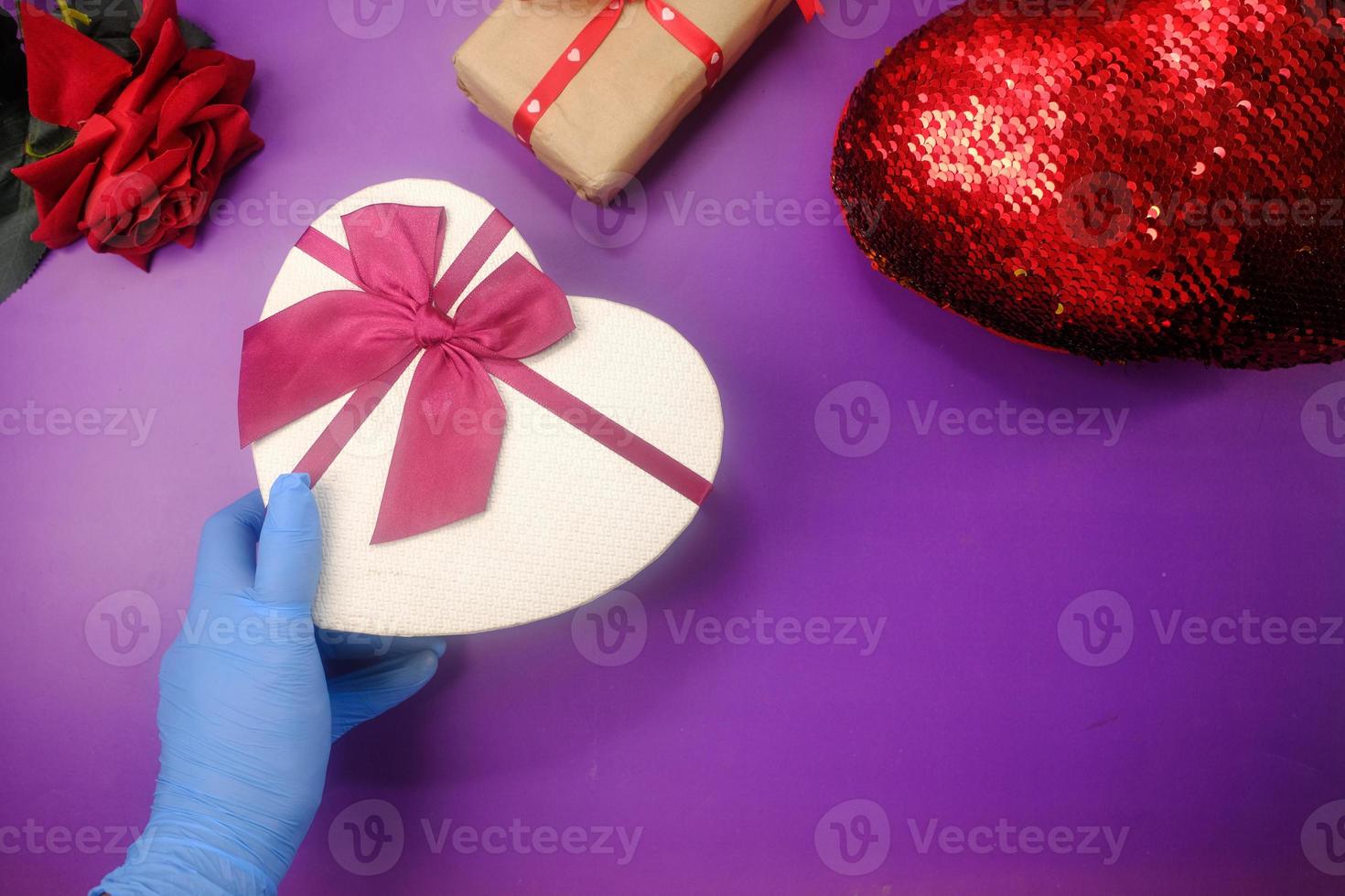 la mano maschio in un guanto medico blu dà un regalo foto