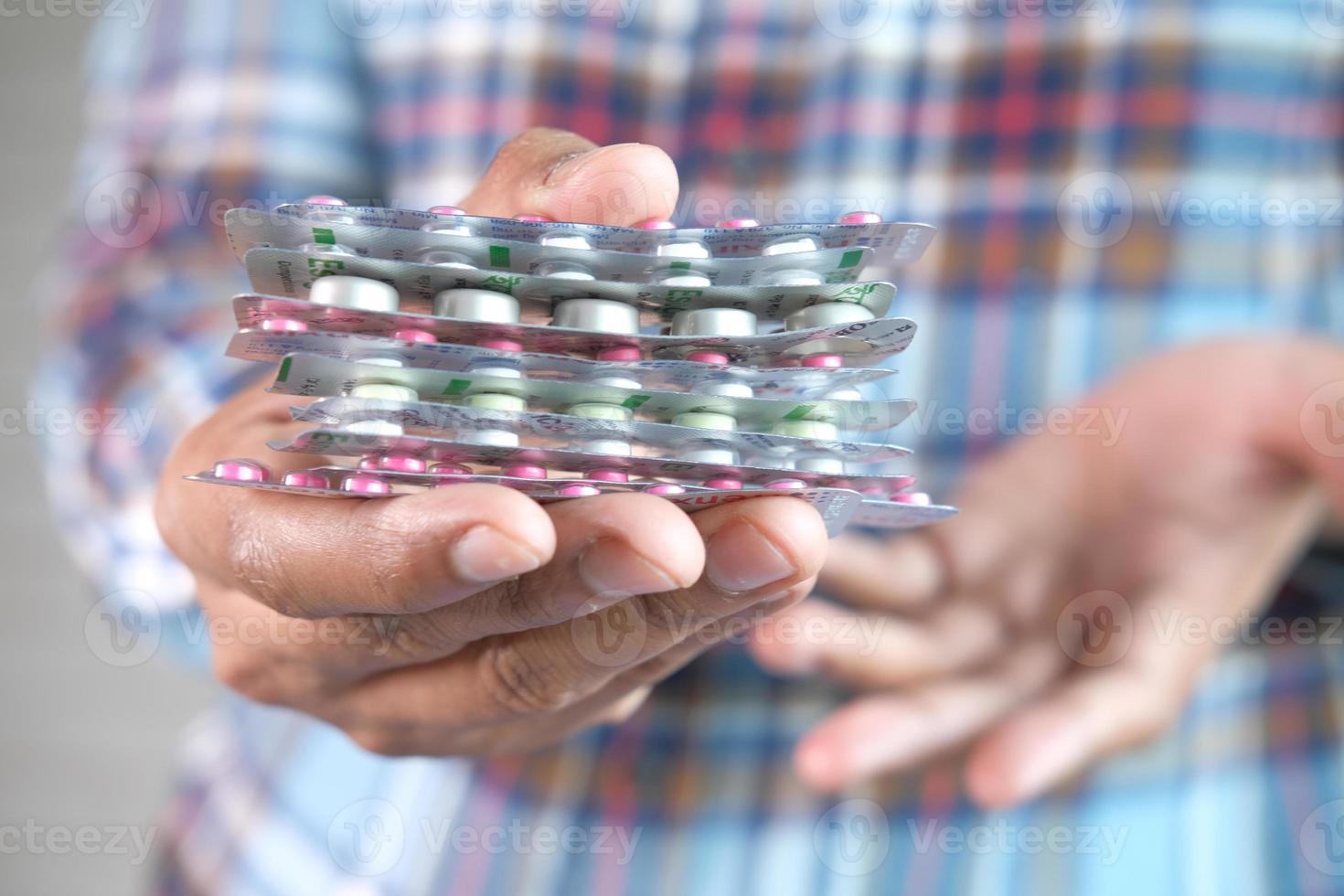 primo piano della mano che tiene i blister di medicina foto