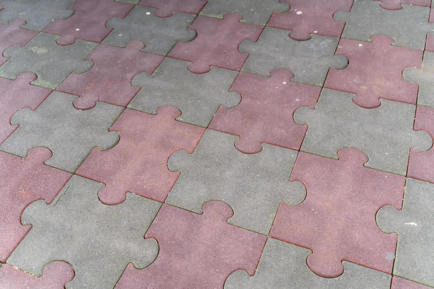 pietre per lastricati a forma di puzzle grigio e rosa consumate foto
