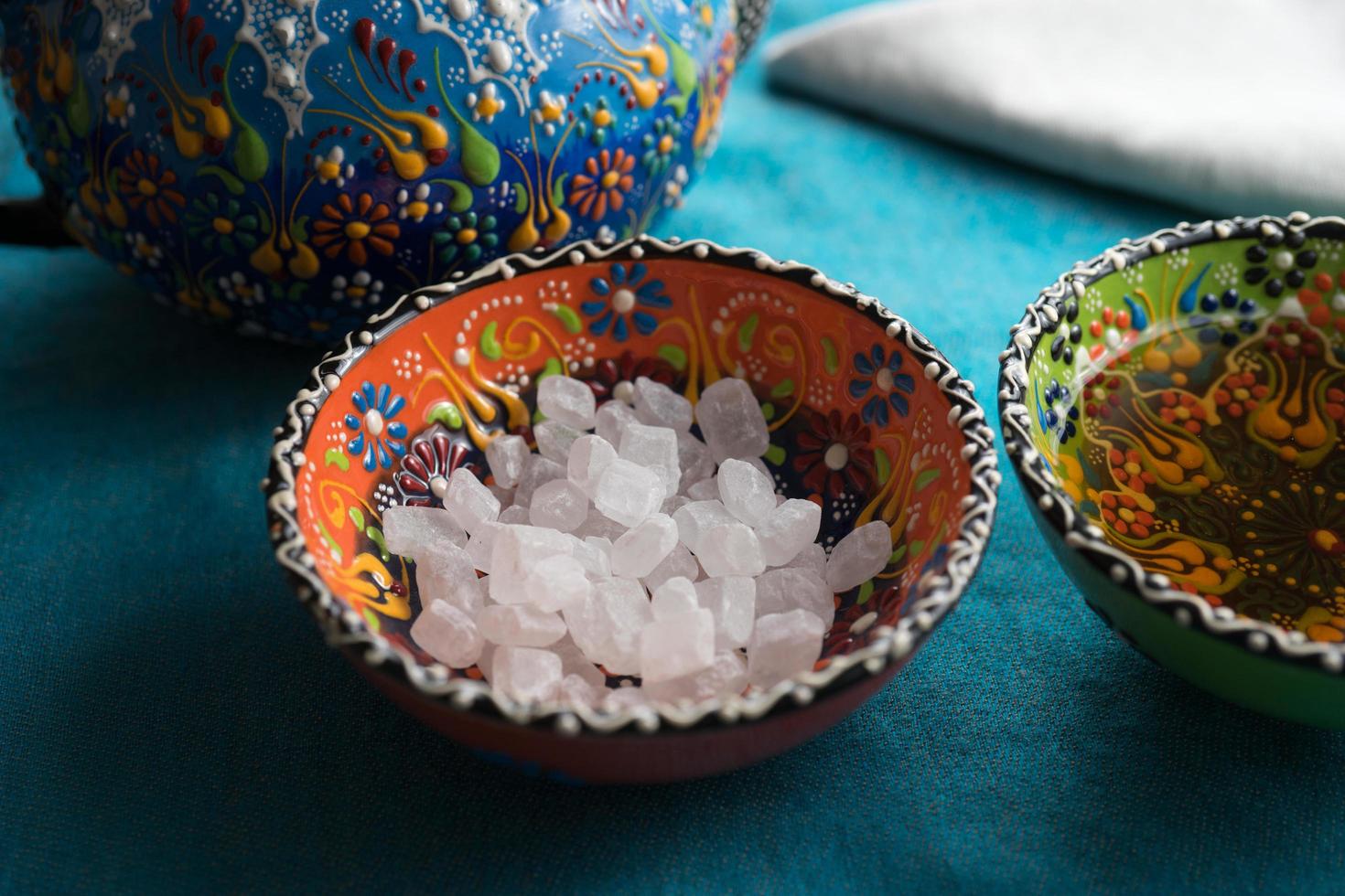 grandi cristalli di zucchero bianco in ciotole di ceramica a motivi colorati foto