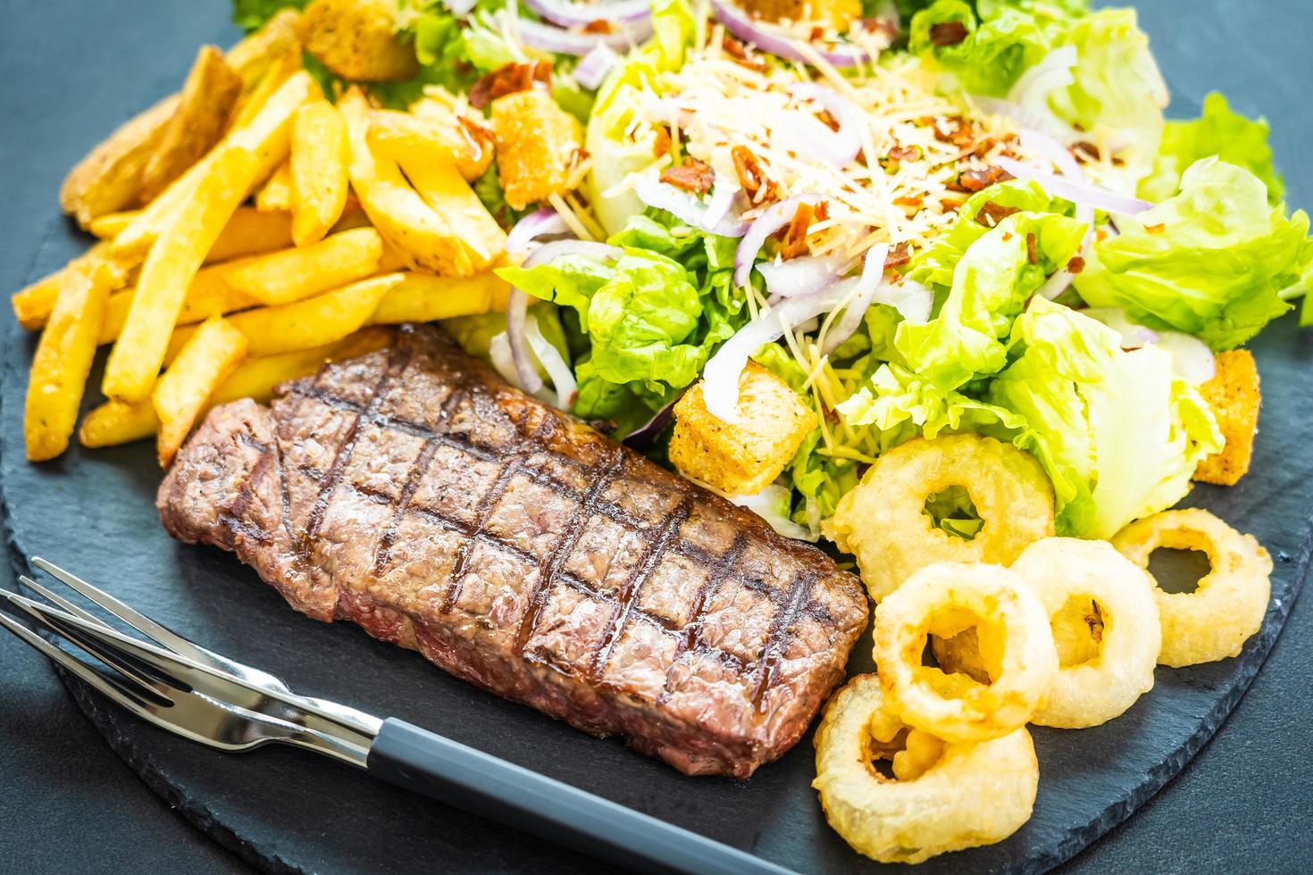 bistecca di manzo alla griglia con patatine fritte e verdure fresche foto