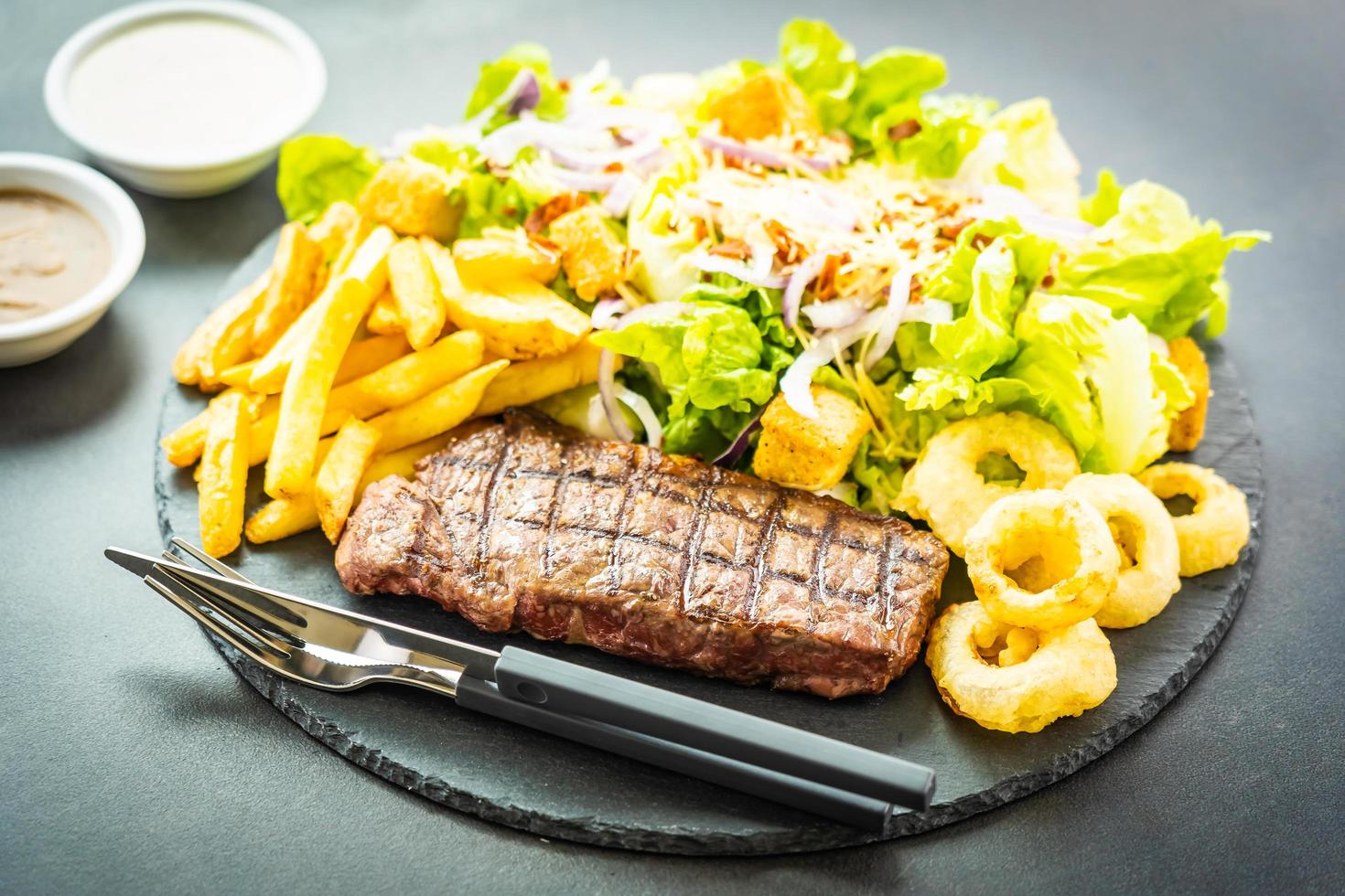 bistecca di manzo alla griglia con patatine fritte e verdure fresche foto