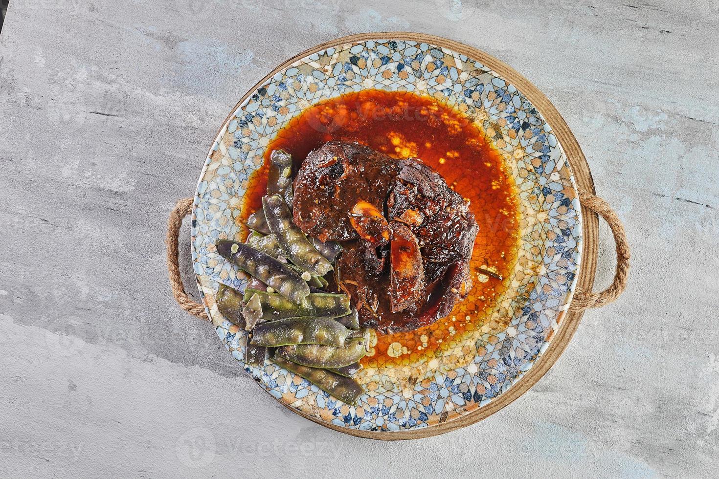 agnello confit con neve piselli nel salsa su piatto foto