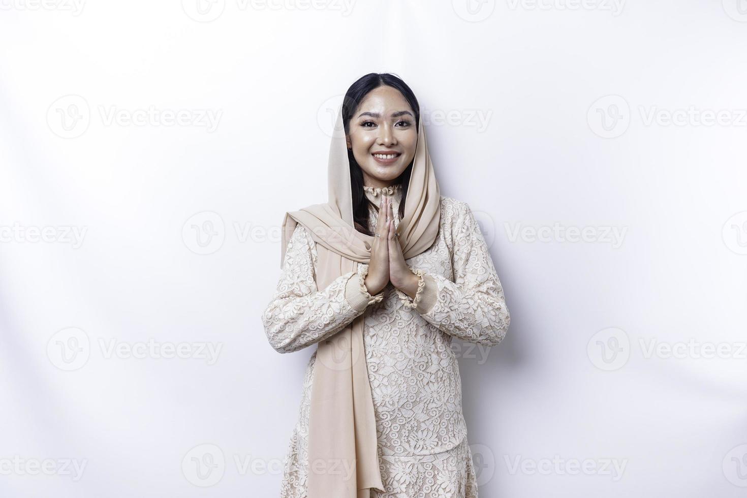 ritratto di un' giovane bellissimo asiatico musulmano donna indossare un' hijab Esprimere a gesti eid mubarak saluto foto