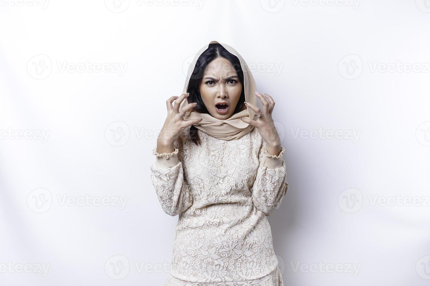 un' insoddisfatto giovane asiatico musulmano donna sembra a il telecamera in posa su un' bianca sfondo, scontento ragazza con irritata viso espressioni mostrare negativo atteggiamento foto
