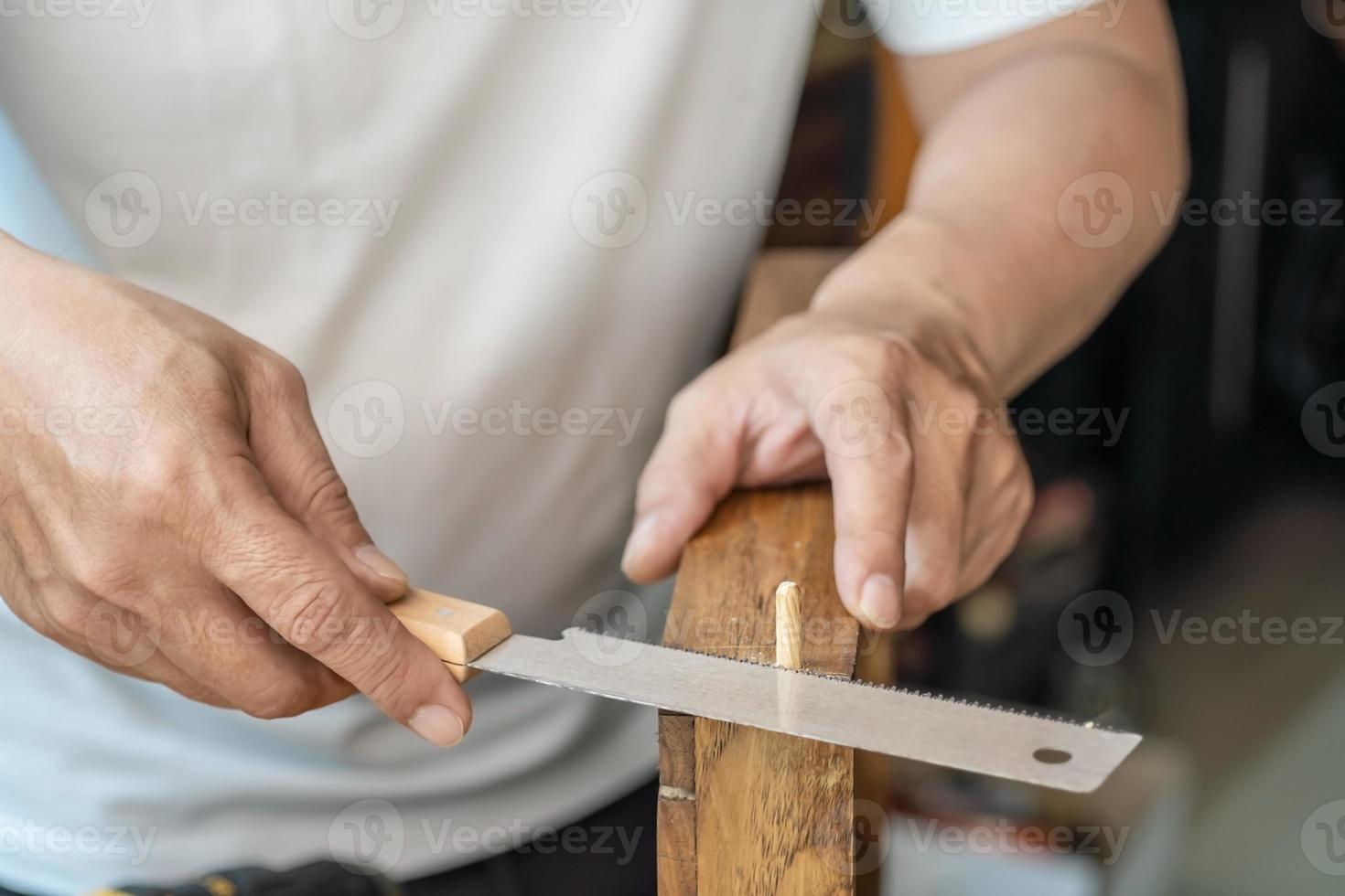 Falegname che usa una sega per legno per tagliare fogli di legno