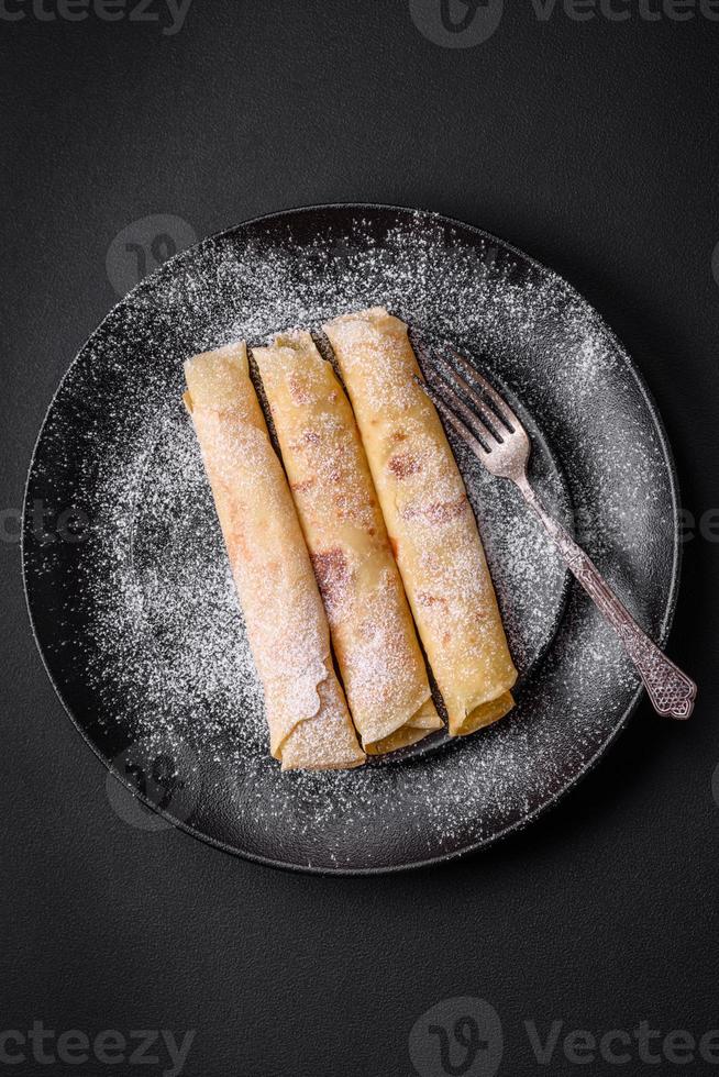 delizioso fresco al forno Pancakes con miele e frutta su un' calcestruzzo sfondo foto